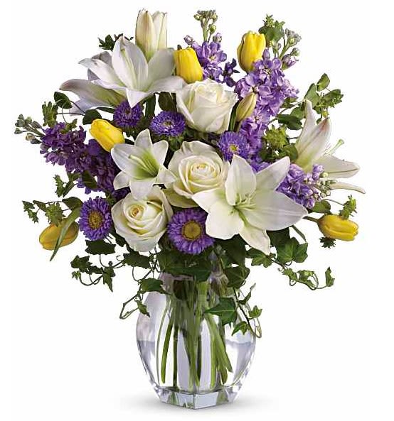 Spring Waltz - Dance into spring! Send this feminine bouquet of favorite spring flowers to brighten someone's home with the playful beauty of nature. Such a pretty way to say, "I'm thinking of you!" -This white, lavender and yellow bouquet includes white asiatic lilies, cream roses, yellow tulips, lavender stock, lavender matsumoto asters and greens including bupleurum, ivy and seeded eucalyptus. Delivered in a gorgeous reception vase. -Orientation: All-Around-