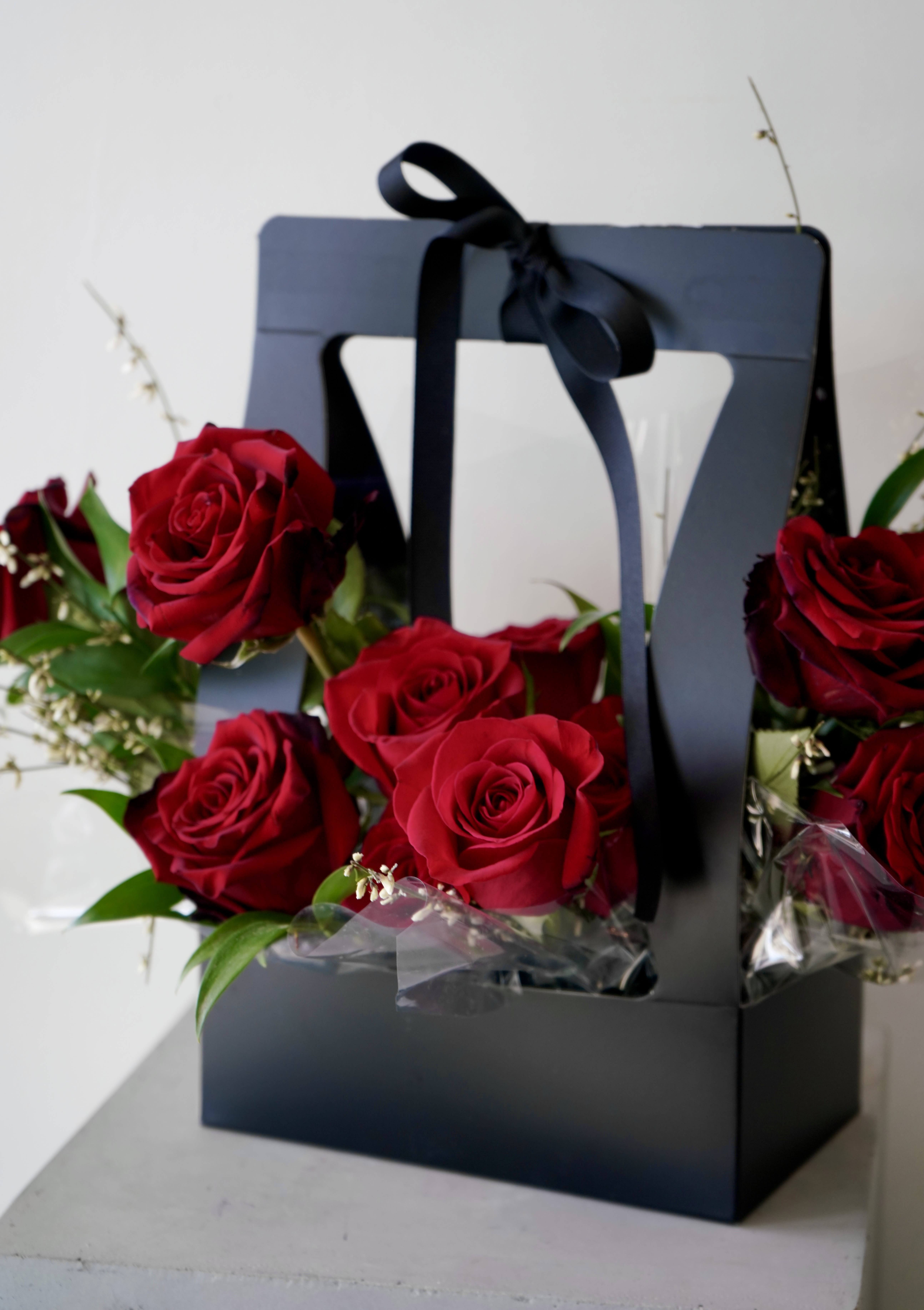 Elegant Black Box - An elegant arrangement of red roses, white fillers, and greenery for a romantic gift.