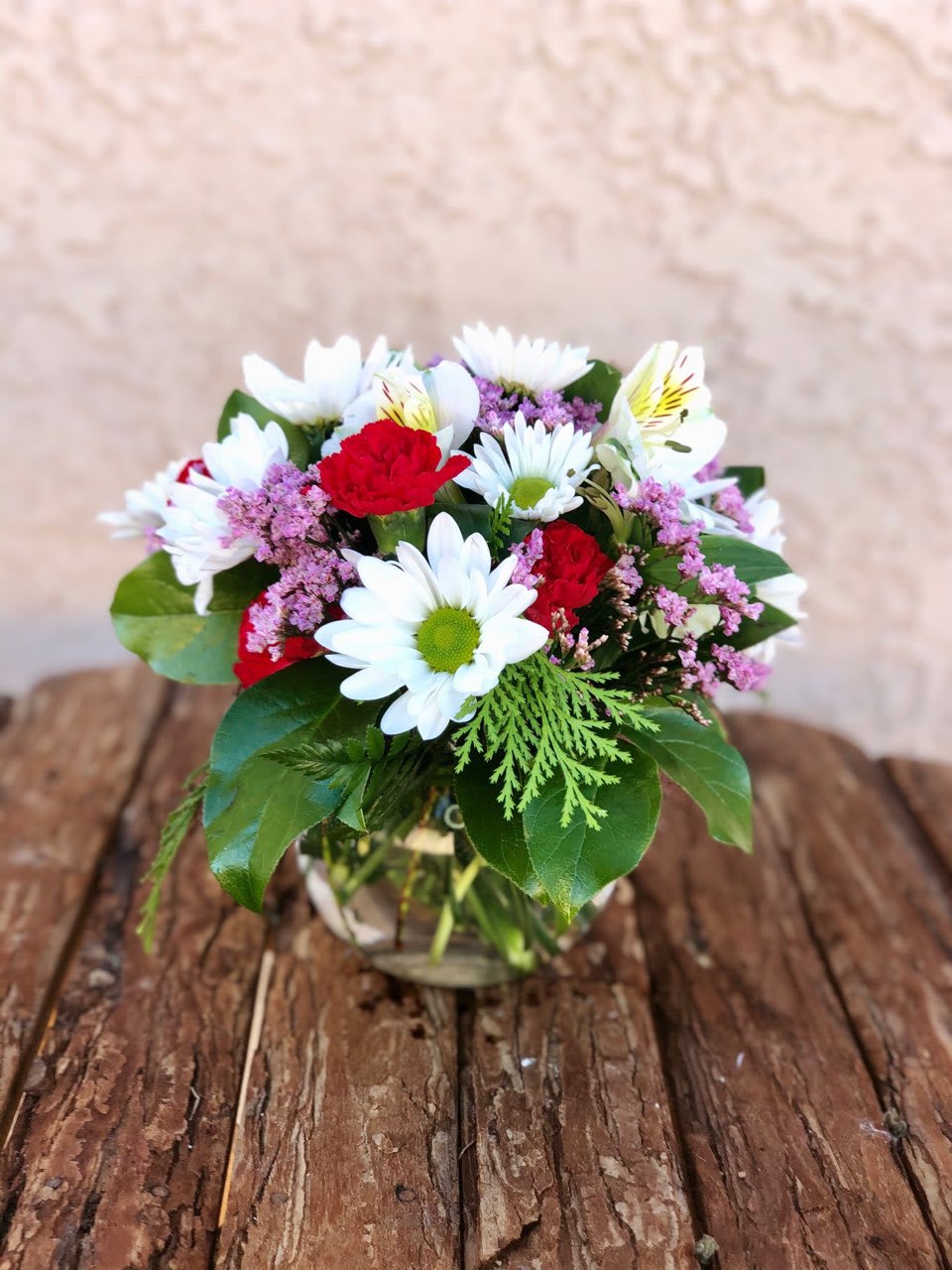 Bubbly Love - What a sweet way to let someone know you're thinking of them. This charming little pop of an arrangement features daisy poms, miniature carnations, long lasting alstromeria and a sweet hint of limonium or babys breath all tucked into a 4" Bubble Vase. This palm-sized cutie is the perfect size for a desk or cubicle. ***Tones and greens may vary according to availability.  Approximately 6"w x 8"t  This arrangement can be created in different color combinations, so if you would like something different please let us know in the special instructions.   