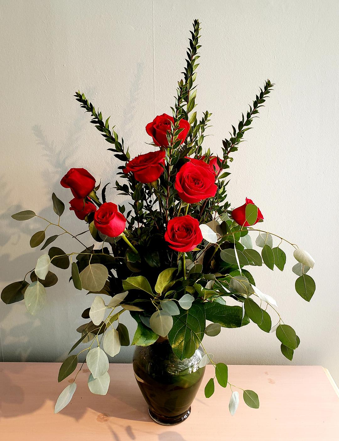 Dozen Long Stemmed Roses - This is how we do roses at Petals...Arranged in a beautiful tall glass vase with a variety of greens. Tall and sexy. No babies breath here unless you request it.Available in any color with a days notice.