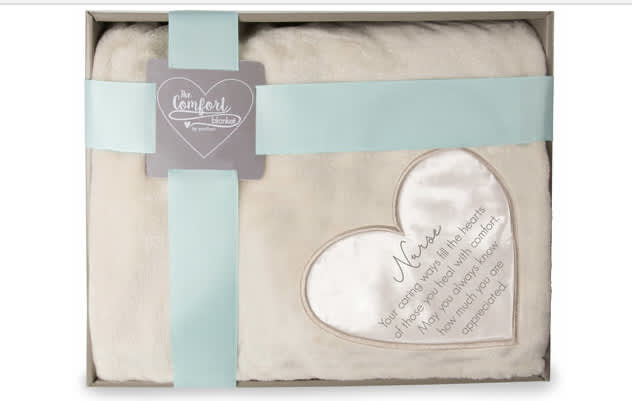 Cream comfort blanket in a gift box with blue ribbon and heart patch printed with a nurse appreciation message.