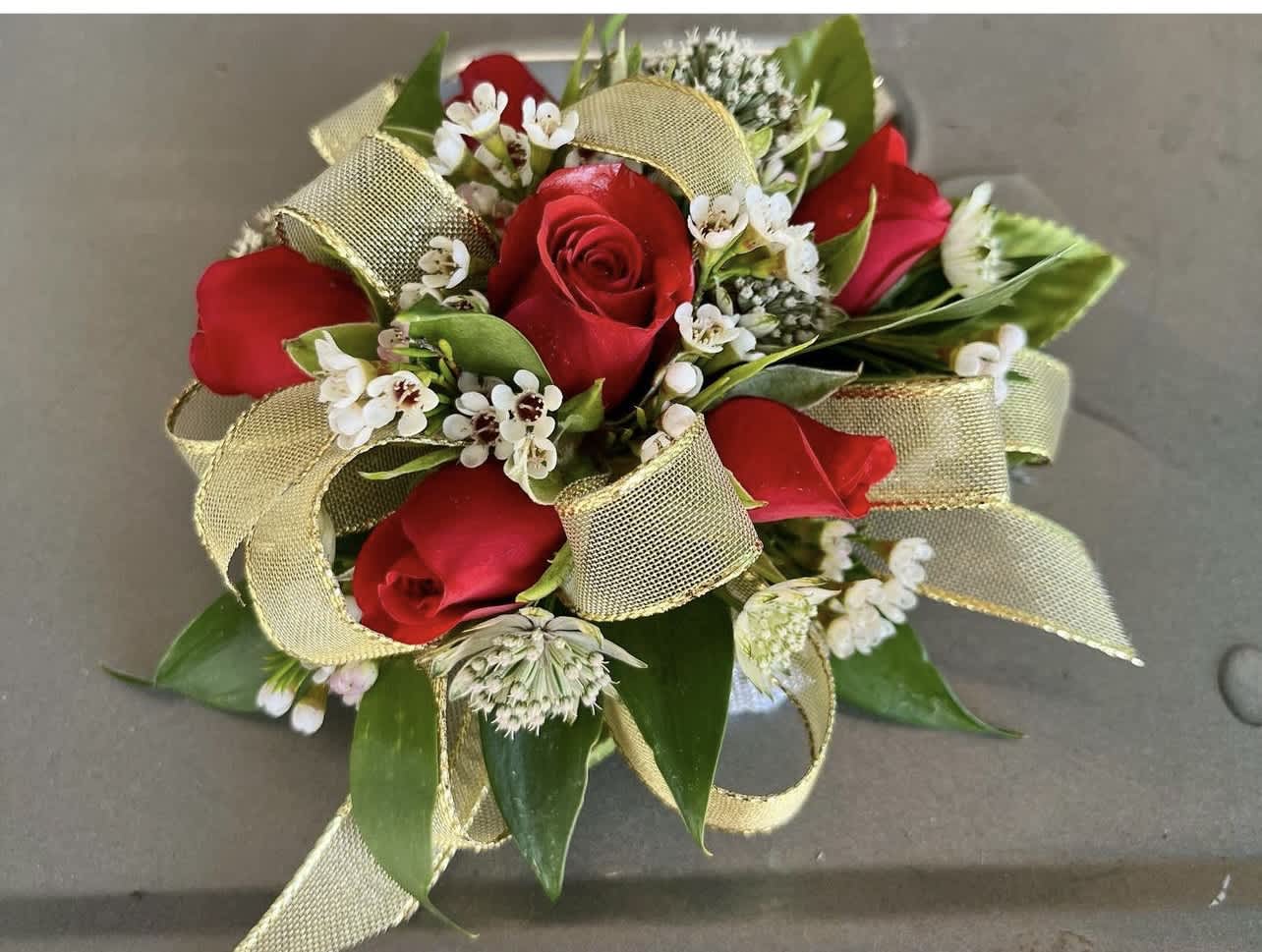 Red rose wrist corsage with white filler flowers and gold ribbon loops