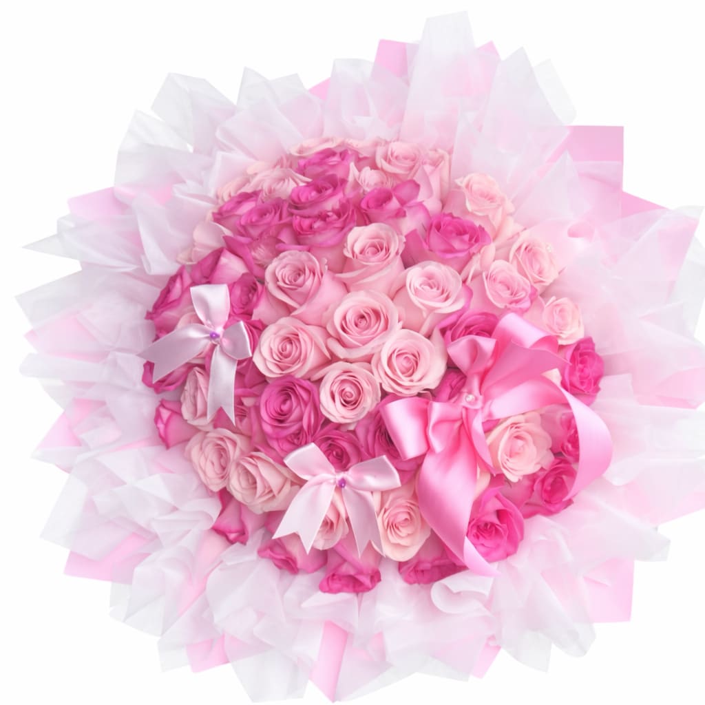 Blush Princess Rose Bouquet - A lush, rounded cluster of light and hot pink roses creates an immediate romantic impact-this blush princess rose bouquet is the kind of birthday bouquet or anniversary roses that makes the person you're honoring feel cherished. The mix of soft and vibrant pinks reads like a gentle gradient across the tightly packed blooms, while touches of white keep the palette fresh and luminous-perfect for romantic gestures, celebrations of love, or to say "you're special" on any milestone.  The bouquet is wrapped in layered pink and white tissue that fans outward like a ruffled halo, giving the arrangement a soft, cloud-like frame. Multiple pink satin ribbon bows, some accented with small beads, are tucked into the arrangement and along the edge for a gift-ready, feminine finish. The dense, rounded shape emphasizes rose petal texture and gives a luxurious, full look that holds its form from presentation through delivery.  Ideal for a partner, mother, or close friend who loves classic romance, this bouquet reads as both celebratory and intimate-the kind of floral gift that makes someone feel truly seen. Order in time for birthdays, anniversaries, or "just because" moments; handle gently and keep in fresh water away from direct heat to prolong bloom life.