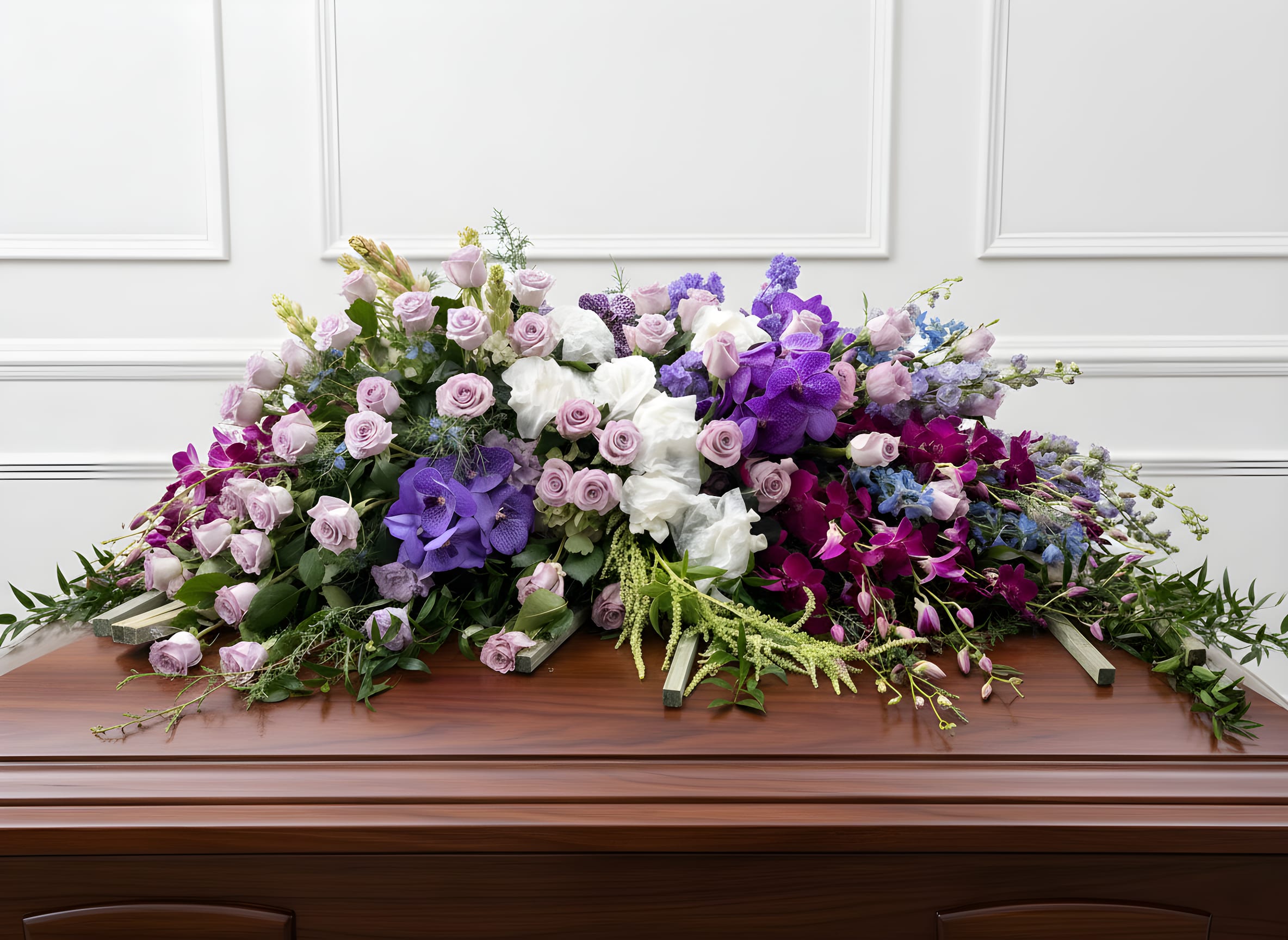Heavenly Garden Grand Casket Spray - Honor a life with beauty, abundance, and heartfelt grace with our Heavenly Garden Grand Casket Spray. This luxurious, full-scale floral tribute is designed with an exquisite blend of lavender, blush, white, and deep purple blooms, creating a rich and layered garden-style design.  Featuring an abundance of premium roses, orchids, Gardenias , hanging Amaranthus and seasonal flowers, this arrangement is thoughtfully styled with flowing greenery and soft textures that create a sense of movement, elegance, and peace.  Designed to gracefully adorn the casket, this grand piece symbolizes love, remembrance, and the beauty of a life deeply cherished. Its lush, overflowing design offers a powerful and comforting presence during funeral services, memorials, or celebration of life ceremonies.  Each arrangement is carefully handcrafted with compassion and attention to detail, ensuring a one-of-a-kind tribute that reflects dignity, love, and lasting memory.  Serving Rancho Cucamonga and the Inland Empire, we are honored to help you express your sympathy with care, respect, and heartfelt intention.