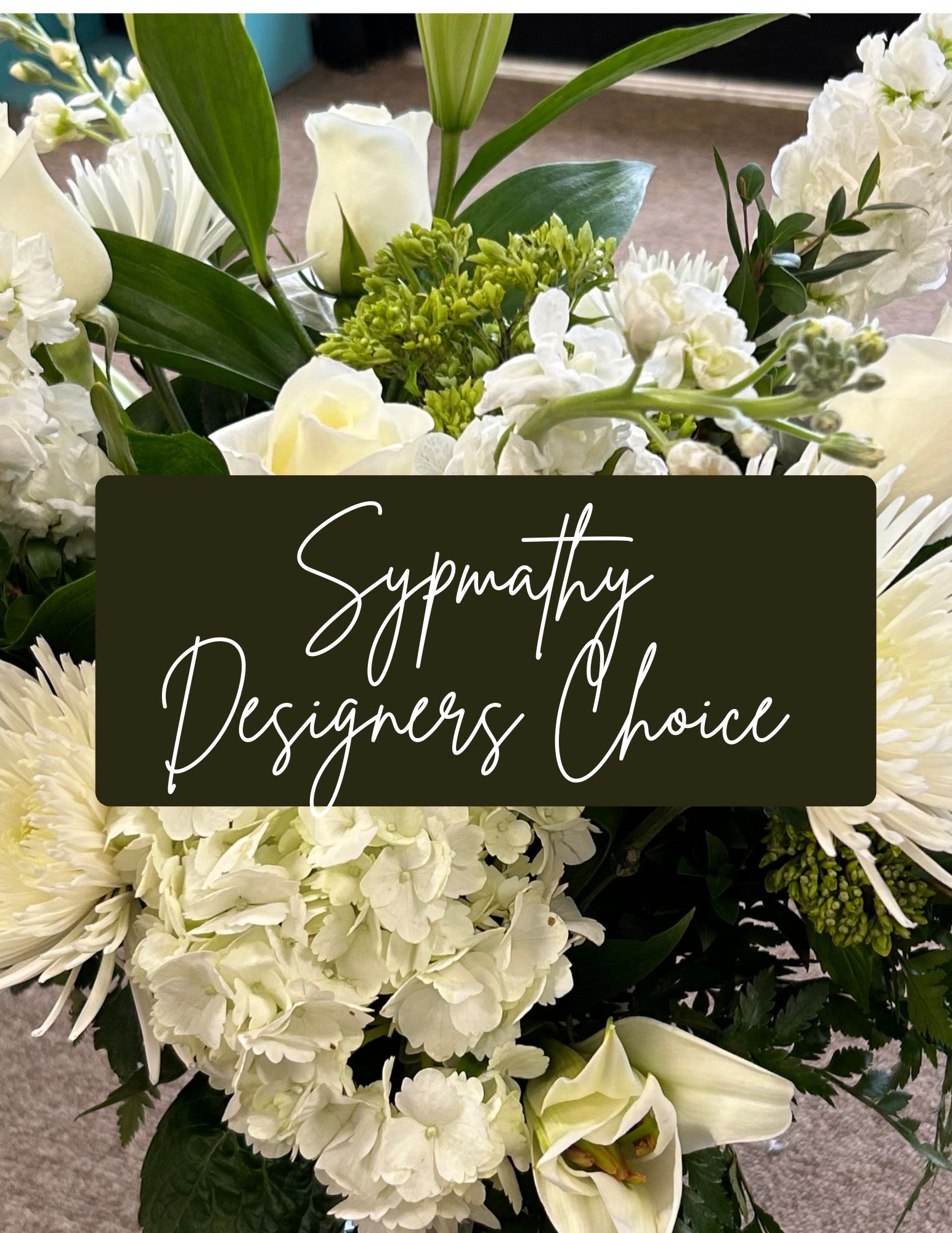 Premium Sympathy Designers Choice  - Pure white roses, lilies, hydrangeas and chrysanthemums come together in a serene sympathy arrangement designed to offer comfort and quiet grace. This white and green funeral spray-style bouquet is made for expressing condolences at a service or sending peace to someone grieving-the kind of thoughtful floral tribute that helps the person you're thinking of feel seen and supported.  Clustered closely for a full, lush look, the arrangement pairs soft-textured blooms with green buds and foliage for gentle contrast and natural depth. The palette stays calm and respectful, with the lilies and hydrangeas providing volume and the roses and chrysanthemums lending timeless elegance. Sized to lay or sit where it will be noticed without overwhelming the space, this designers-choice sympathy arrangement is hand-crafted in our signature white-and-green style for immediate delivery to a service or the family's home.