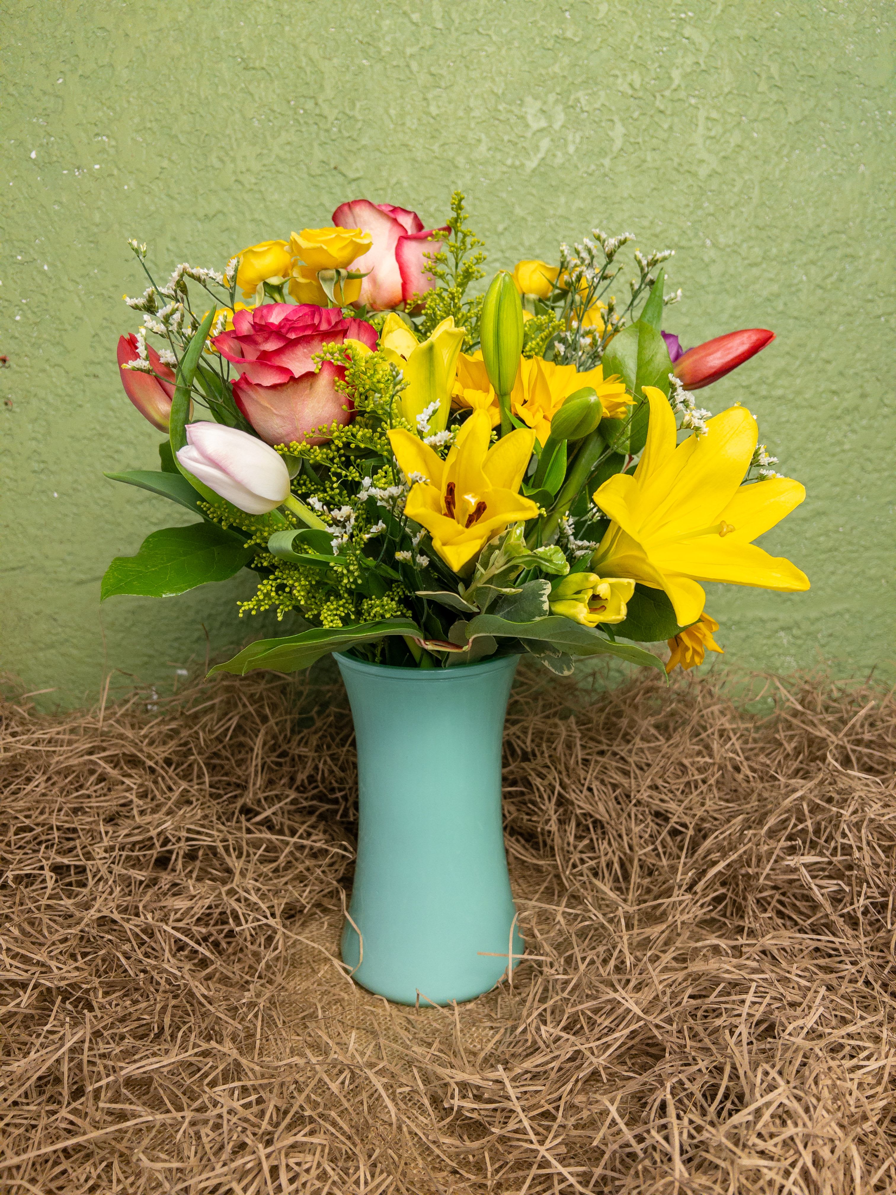Spring Harmony Arrangement - Brighten someone’s day with Spring Harmony, a medium-sized seafoam vase overflowing with sunflowers, lilies, tulips, roses, solidago, and limonium. This cheerful arrangement combines vibrant spring colors in perfect balance, ideal for Easter celebrations or welcoming the new season. Count on your local Baltimore Florist for reliable Flower Delivery in Baltimore and surprise someone with the beauty of spring blooms today.