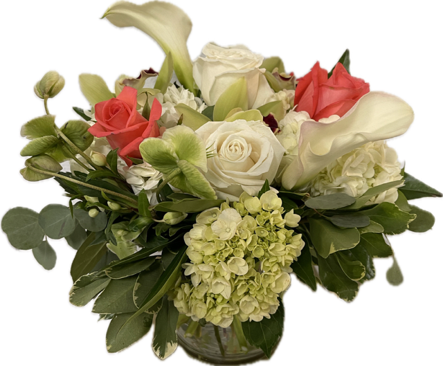 Low glass vase arrangement with white roses, white calla lilies, green hydrangeas, and coral roses.