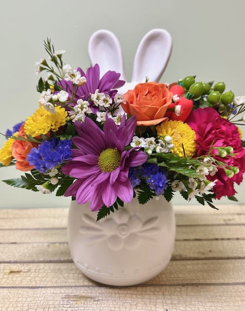 Bunny Crossing ES28 - A bunny crossing your path is a sign that Spring has arrived.  This whimsical arrangement will arrive in a sweet ceramic bunny container filled with colorful spray roses. carnations, and daisies topped with adorable bunny ears.  It's a perfect way to celebrate any spring holiday!  PLEASE NOTE: Container color may vary from the one pictured  