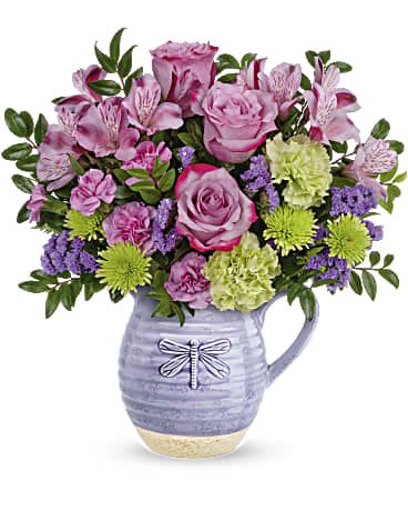 Whimsical Dragonfly Bouquet - Pour on the love with this wonderfully whimsical gift! Bursting with a colorful bouquet, this glazed ceramic pitcher is as practical as it is charming--it's food-safe so they can enjoy it on their breakfast table for years to come! Lavender roses, green carnations, purple sinuata statice, lavender alstroemeria, green cushion spray chrysanthemums and miniature lavender carnations are arranged with huckleberry. Delivered in a Whimsical Dragonfly pitcher.   Approximately 15 1/4" W x 15" H