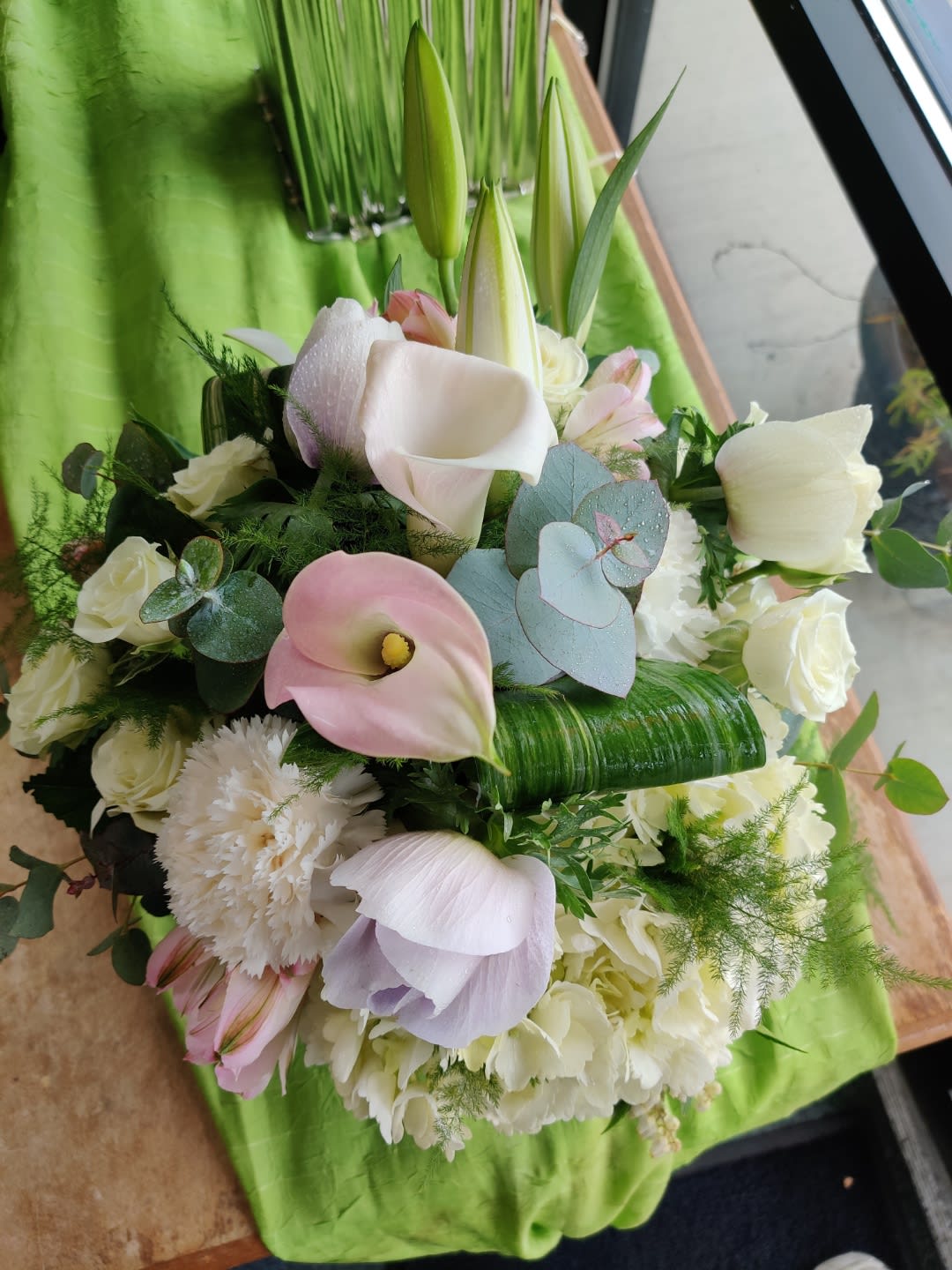Soft Pastels - Includes Calla Lilies, Roses, Anemone, Hydrangeas, Lilies, Carnations, eucalyptus, Aspidistra,and plumosa in a cube glass container