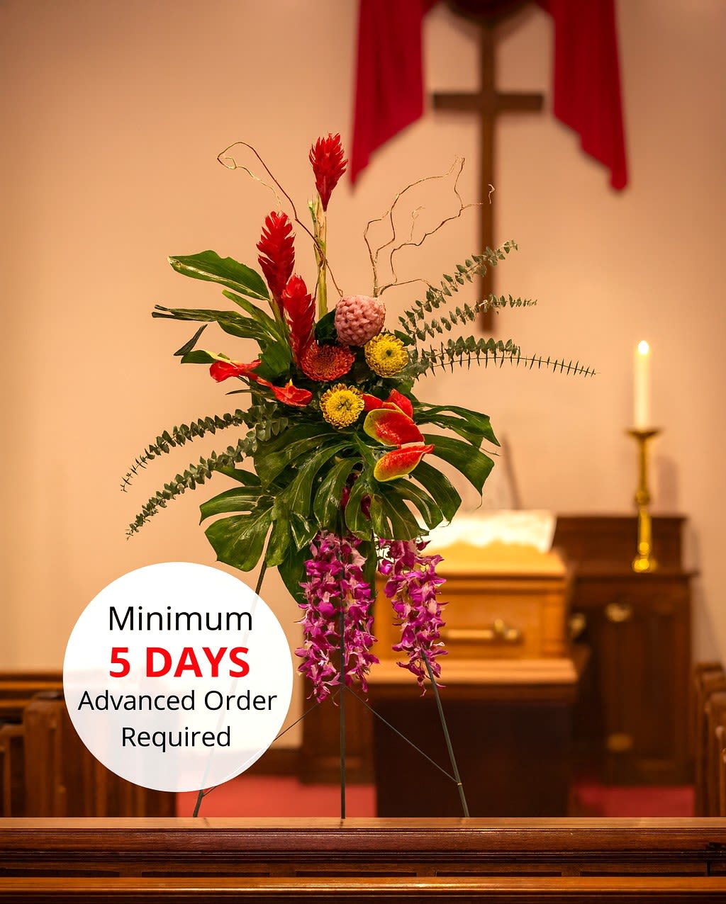 Tall tropical standing spray with red and purple flowers on an easel in a church