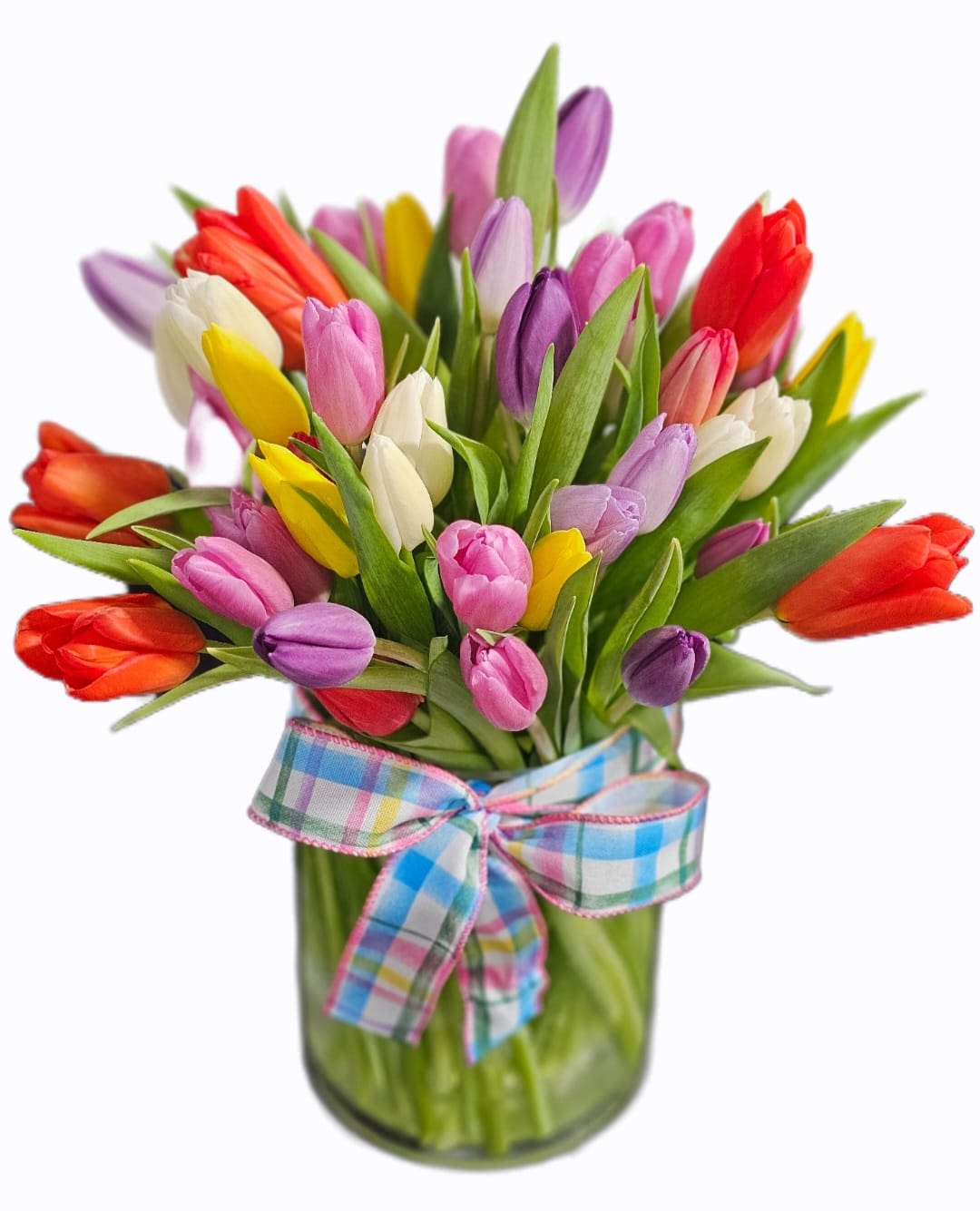 Tulip Jubilee - Celebrate the beauty of spring with our vibrant Tulip Jubilee arrangement. Featuring a stunning mix of fresh-cut tulips in radiant shades of red, yellow, pink, purple, and white, this cheerful bouquet is full of color and charm. Each bloom is carefully arranged to create a lush, garden-fresh look bursting with life.  Presented in a clear glass vase and finished with a soft pastel plaid ribbon, Tulip Jubilee brings a touch of sweetness and seasonal elegance to any space.  Perfect for birthdays, spring celebrations, Easter, thank-you gifts, or simply brightening someone’s day, this joyful arrangement delivers freshness, color, and happiness in every stem.   SUBSTITUTION POLICY Please note the bouquet pictured reflects our original design.  If the exact flowers or container in this arrangement are not available, our local florists will create a beautiful bouquet with the freshest available flowers.