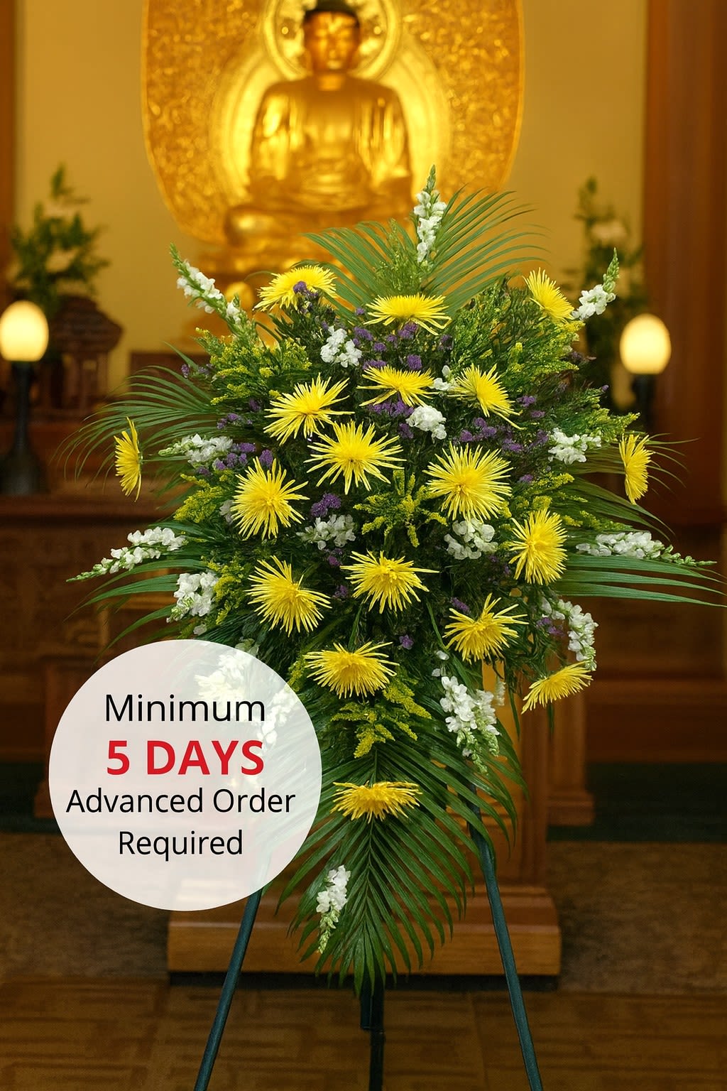 Tall standing spray of yellow and white flowers on an easel in a temple setting