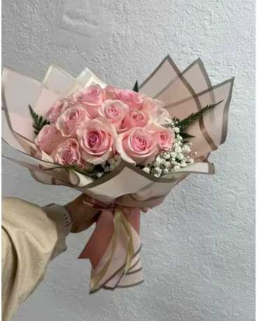 Bouquet of pale pink roses wrapped in blush paper