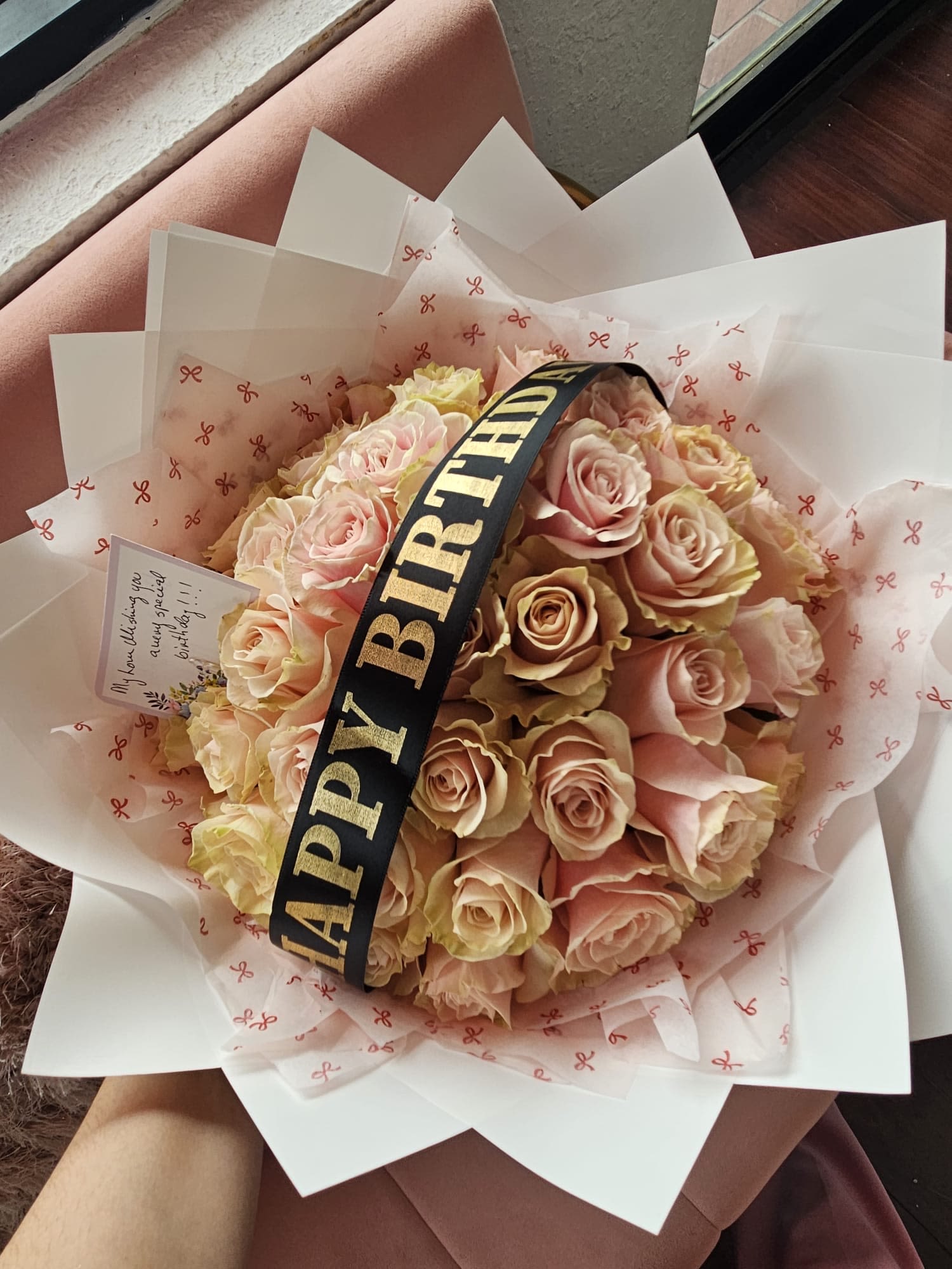 Bouquet of pale pink and cream roses with a birthday ribbon