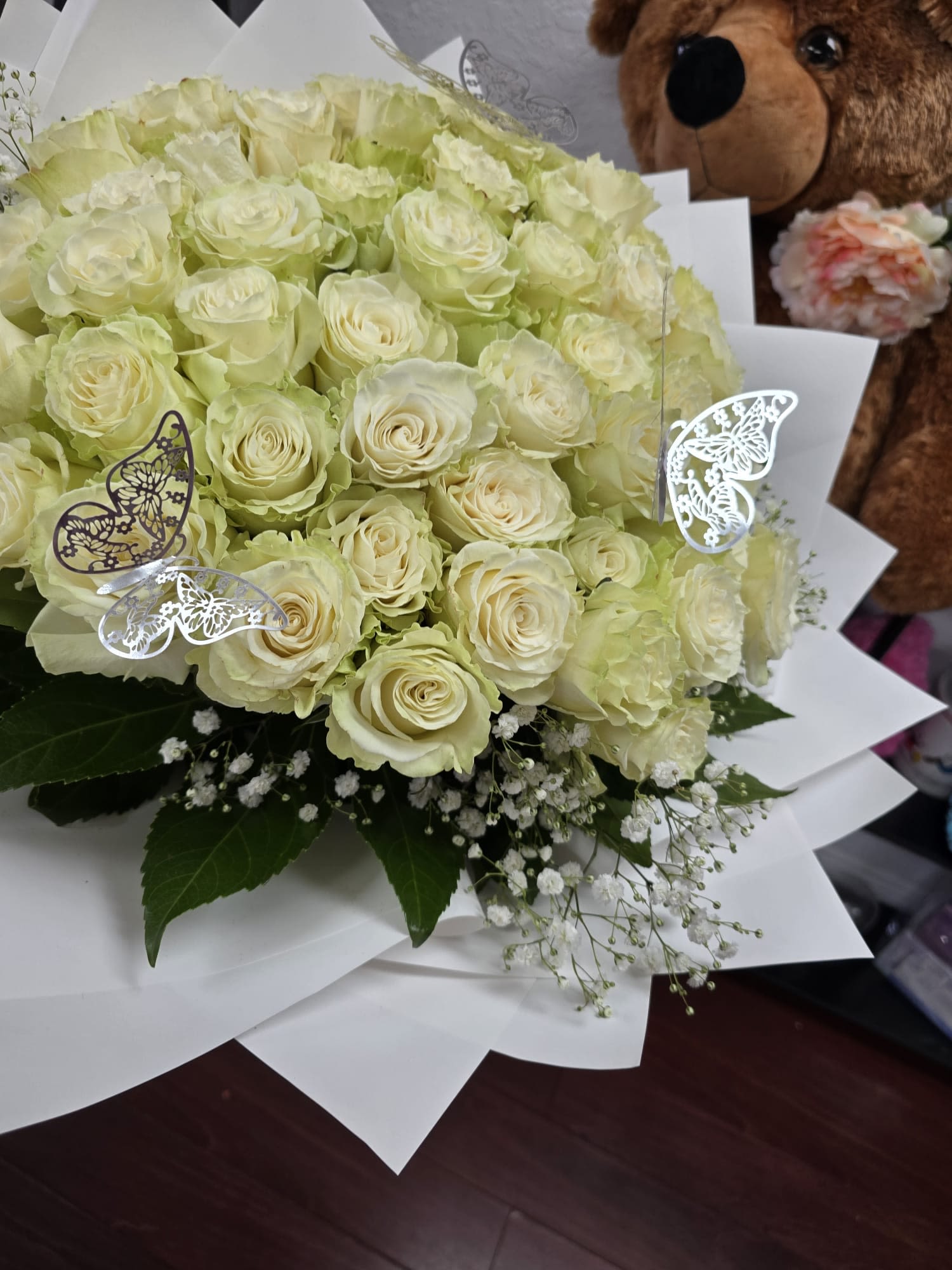 Bouquet of pale cream roses with white baby's breath and butterfly picks