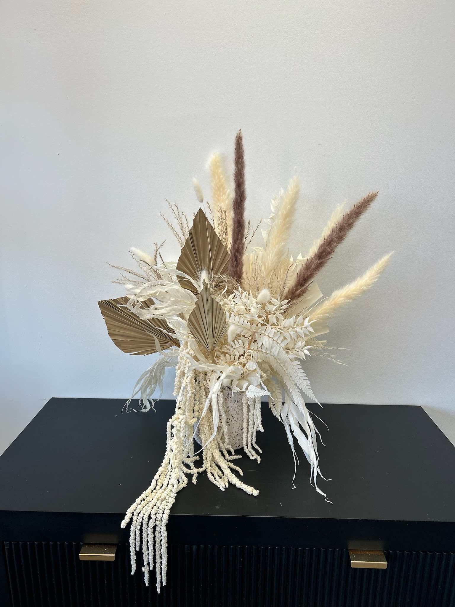Desert Dream - Elevate your space with our Desert Dream, a handcrafted neutral dried flower arrangement designed in soft ivory tones with pampas grass, preserved palms, and textured dried florals. This elegant, long-lasting piece brings a modern boho-inspired touch to any home, office, or event. Perfect for those who love timeless floral decor, this arrangement requires no water and can be enjoyed for years.