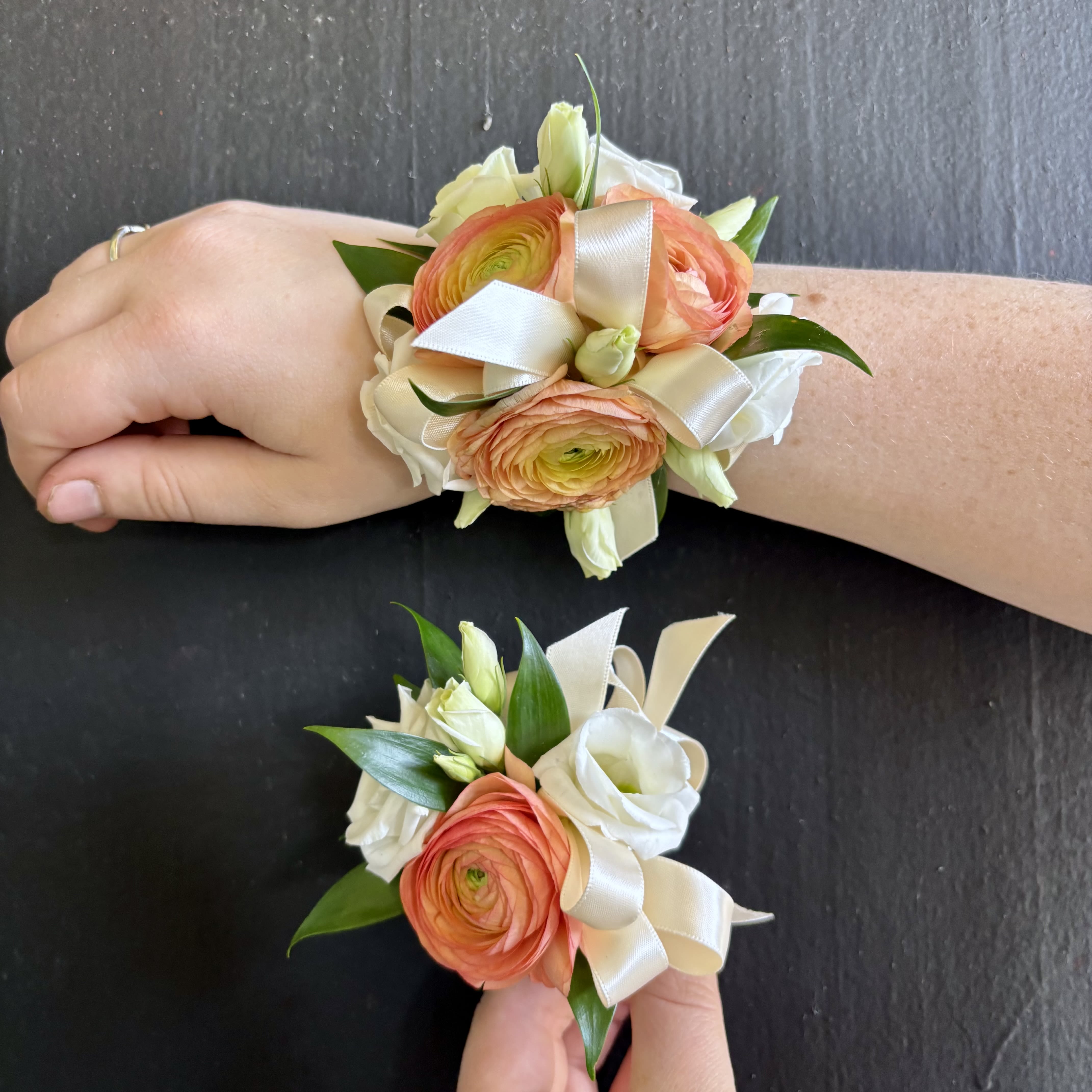 Peach and White Corsage/ Boutonniere Set - A Corsage and Boutonniere set in Peach and White. Topped off with a silky Ivory ribbon. Our corsages are made with either a silver or gold band.Please let us know in the special instructions section if you would like any substitutions. We will do our best to satisfy your requests. Colors can be substituted only when flowers are available.  