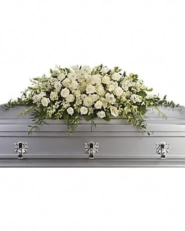 White floral casket spray on a gray casket