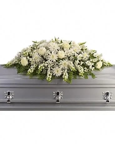 Enduring Light Casket Spray - The purity of this all-white casket spray creates an aura of serenity and peace - a beautifully memorable final farewell to a lost loved one. The elegant arrangement includes white alstroemeria, white snapdragons, white chrysanthemums, white spider chrysanthemums and million star gypsophila, accented with assorted greenery. . 