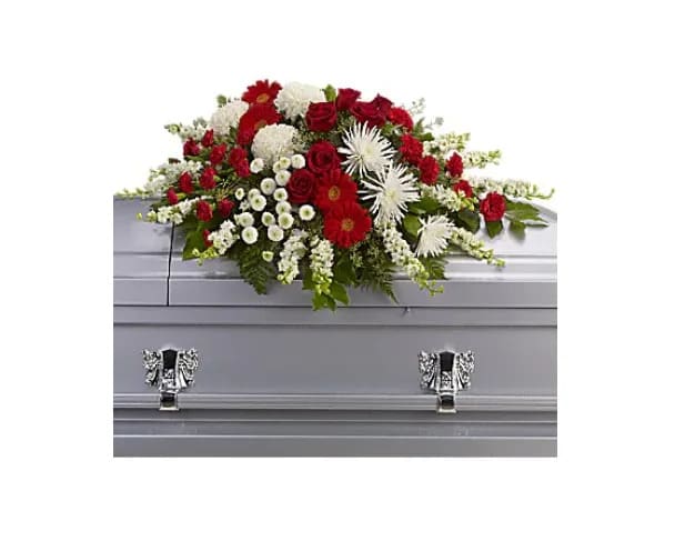 Strength and Wisdom Casket Spray - This beautiful red and white spray will deliver strength and the wisdom to know that there will be brighter days ahead. Dazzling red roses and gerberas, brilliant white chrysanthemums and larkspur are arranged with gentle greens to create a strong yet soothing arrangement. 