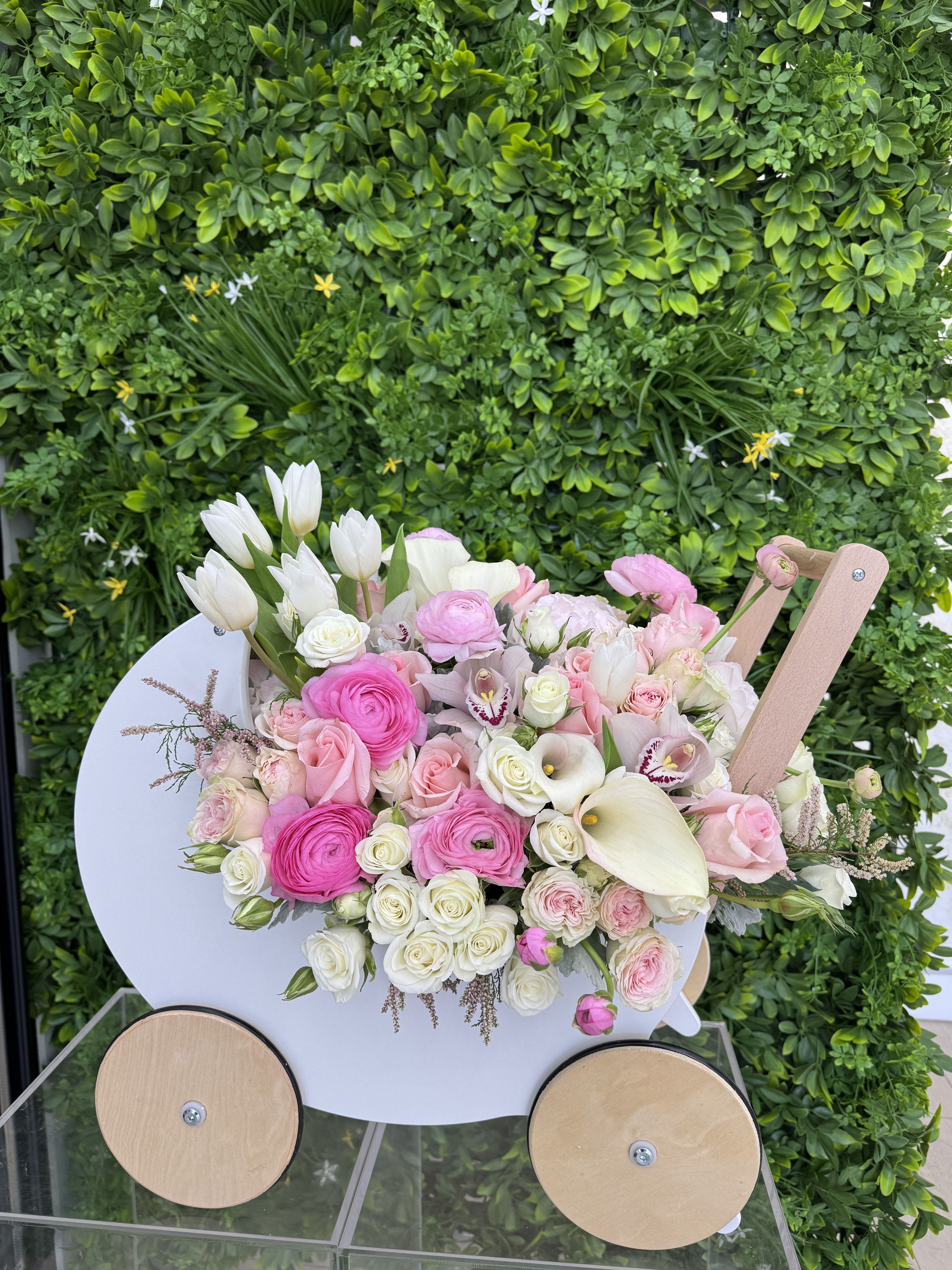 Pink and white mixed bouquet in a white cart-shaped holder