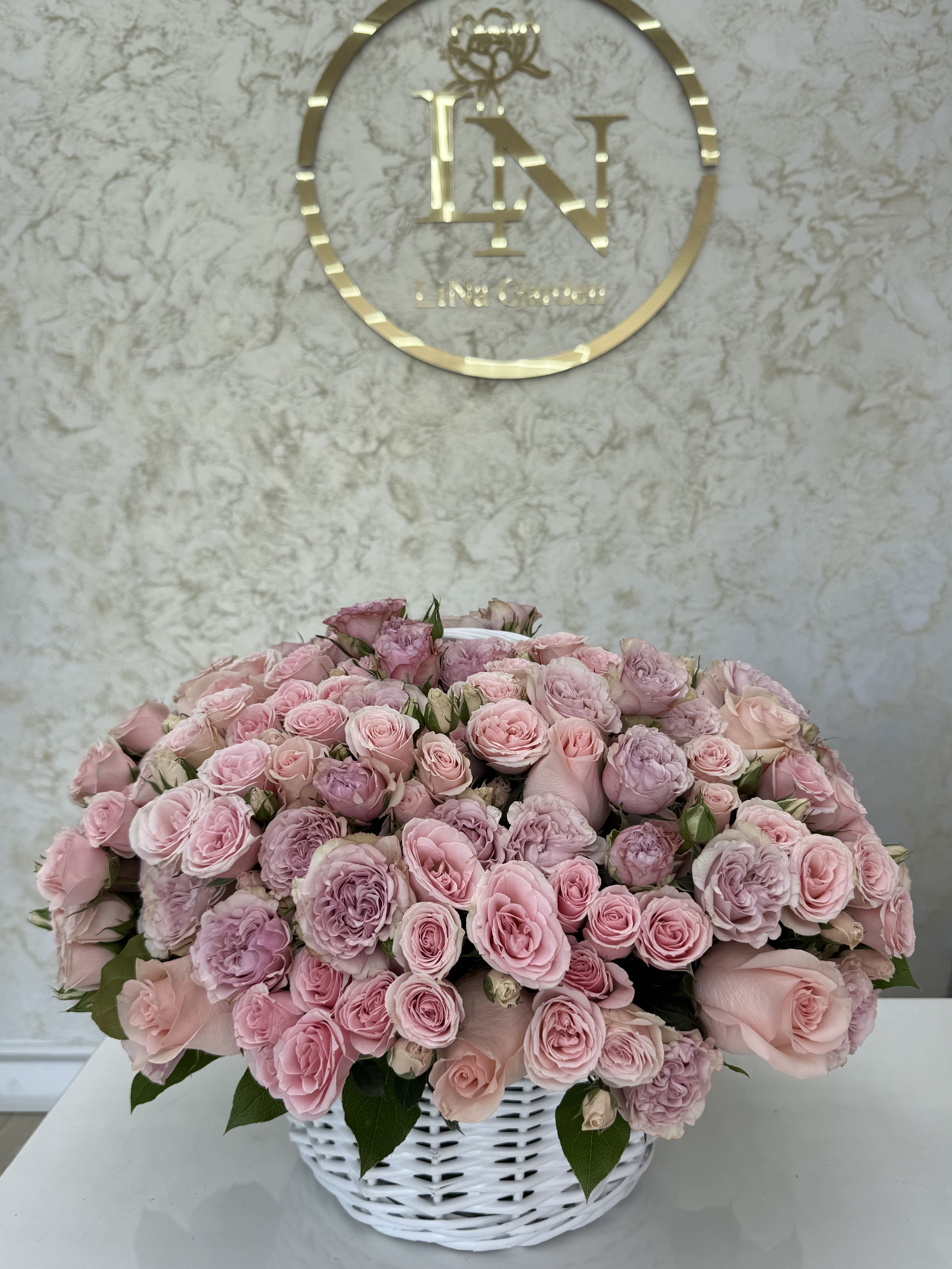 Pink rose bouquet in a white basket vase