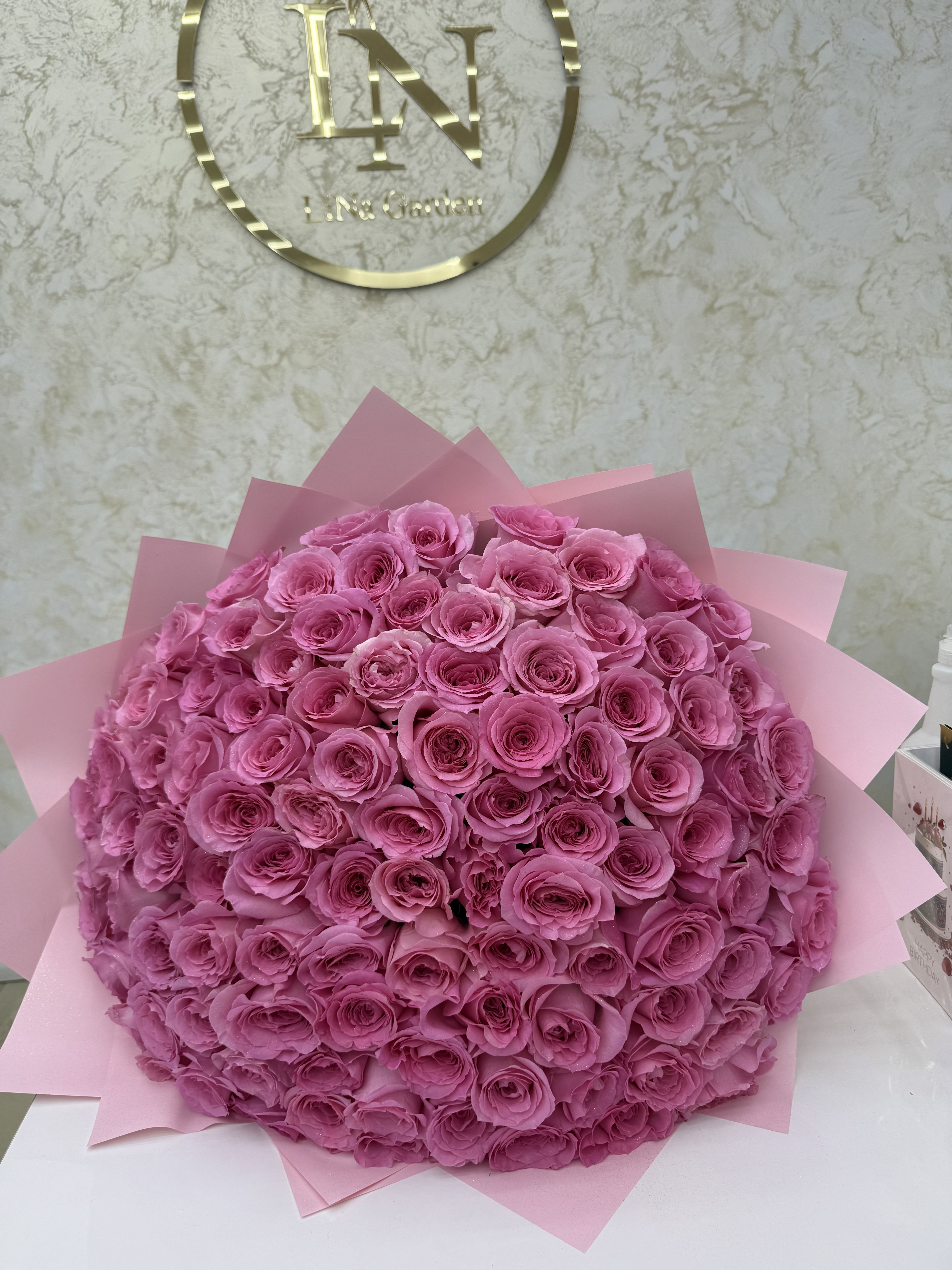 Large bouquet of pink roses wrapped in pink paper