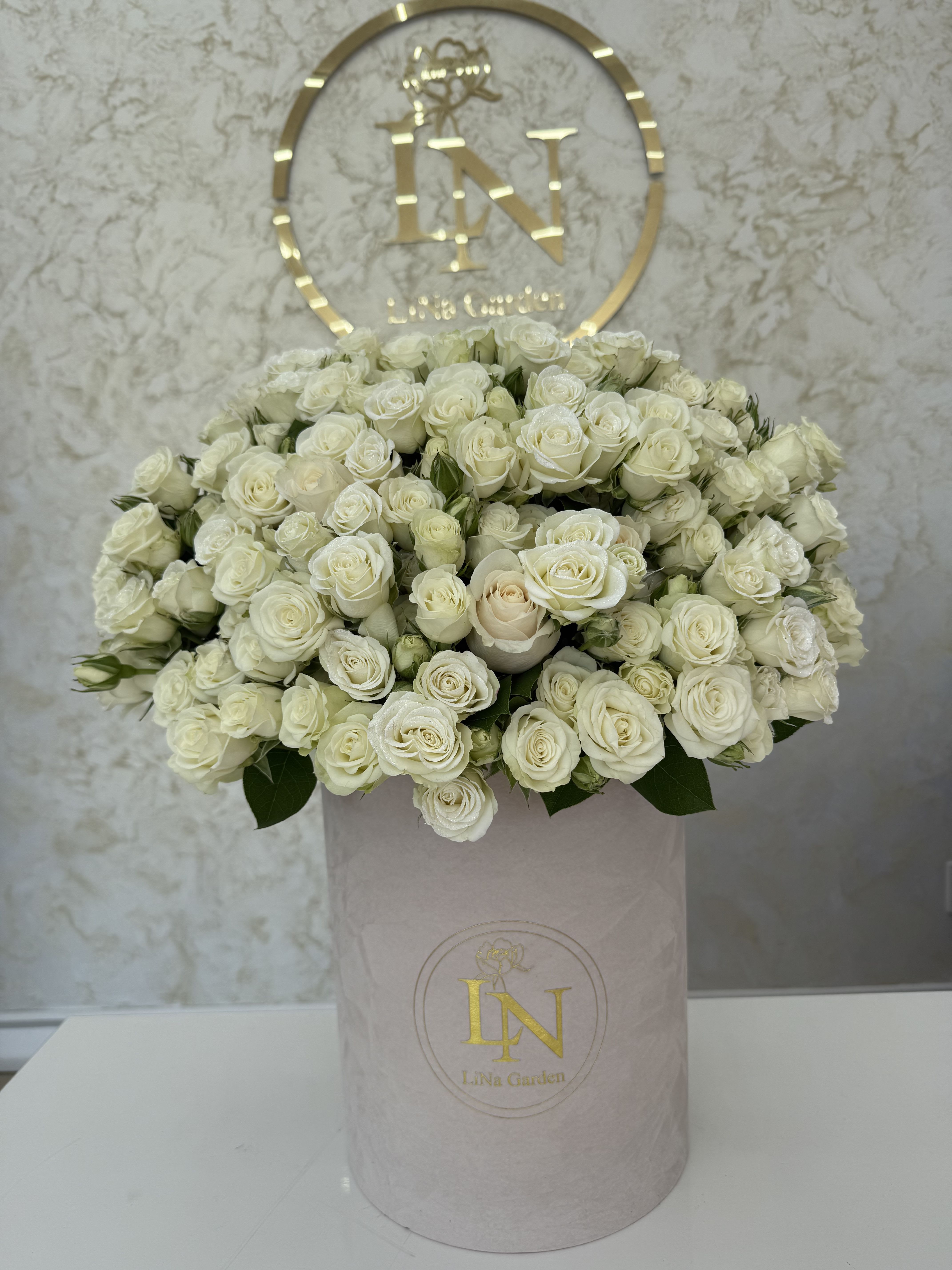 Large bouquet of white roses in a pale pink hat box