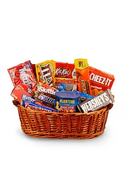 Wicker basket filled with assorted candy bars, snack packs, and a can of nuts.