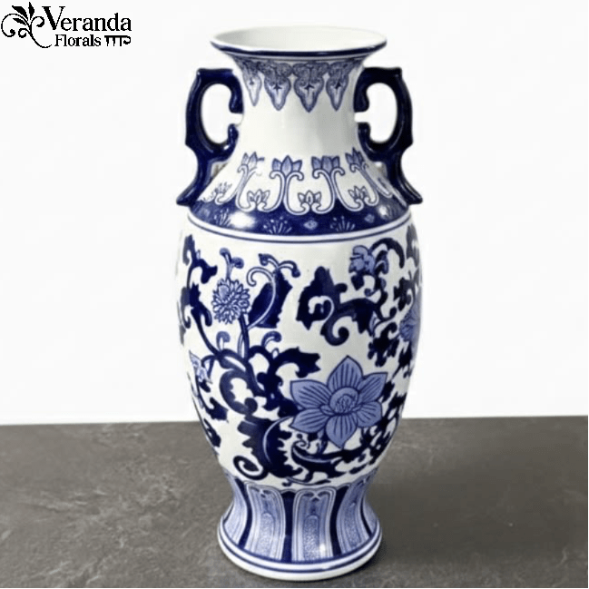 Tall blue and white ceramic vase with handles and floral pattern