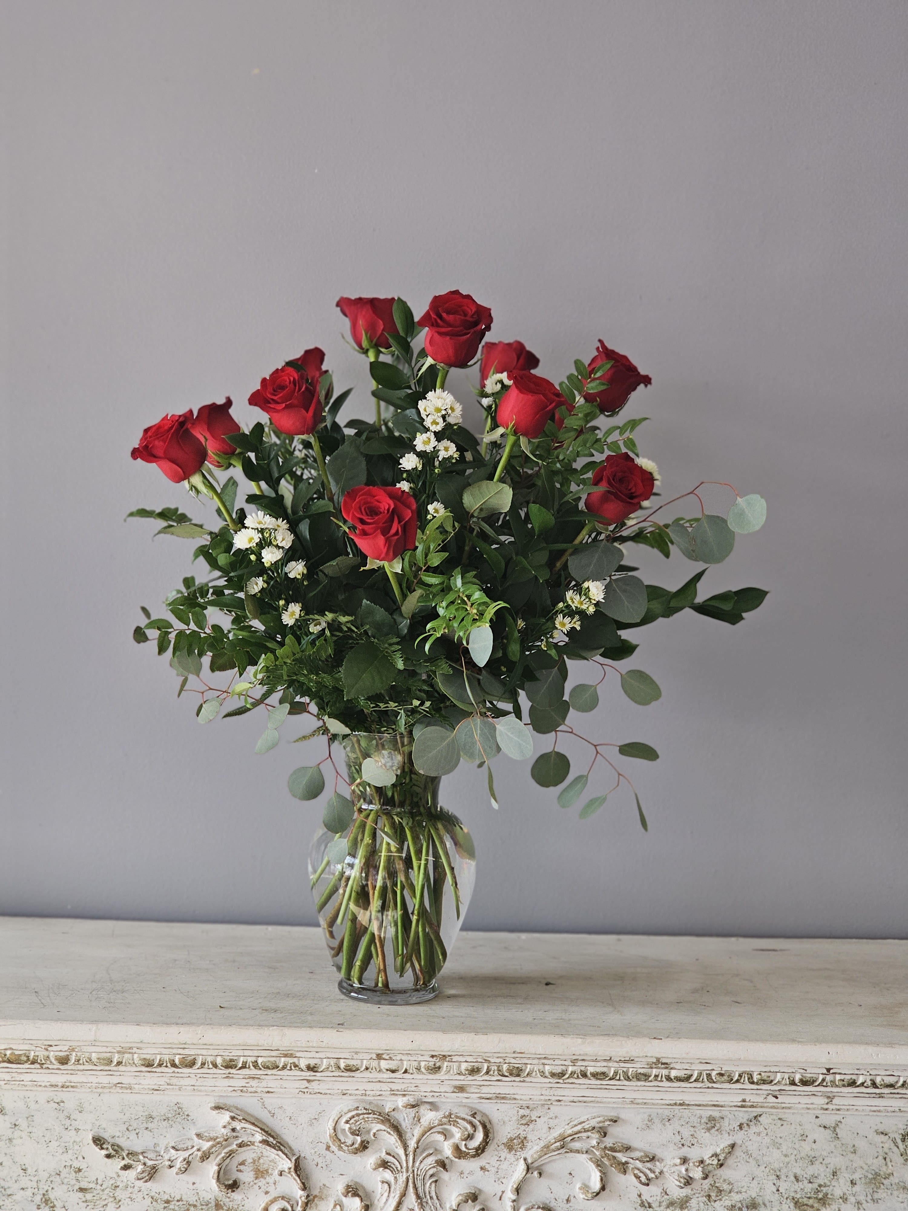 Red Passion - One dozen beautiful red roses arranged in a glass vase with specialty greenery