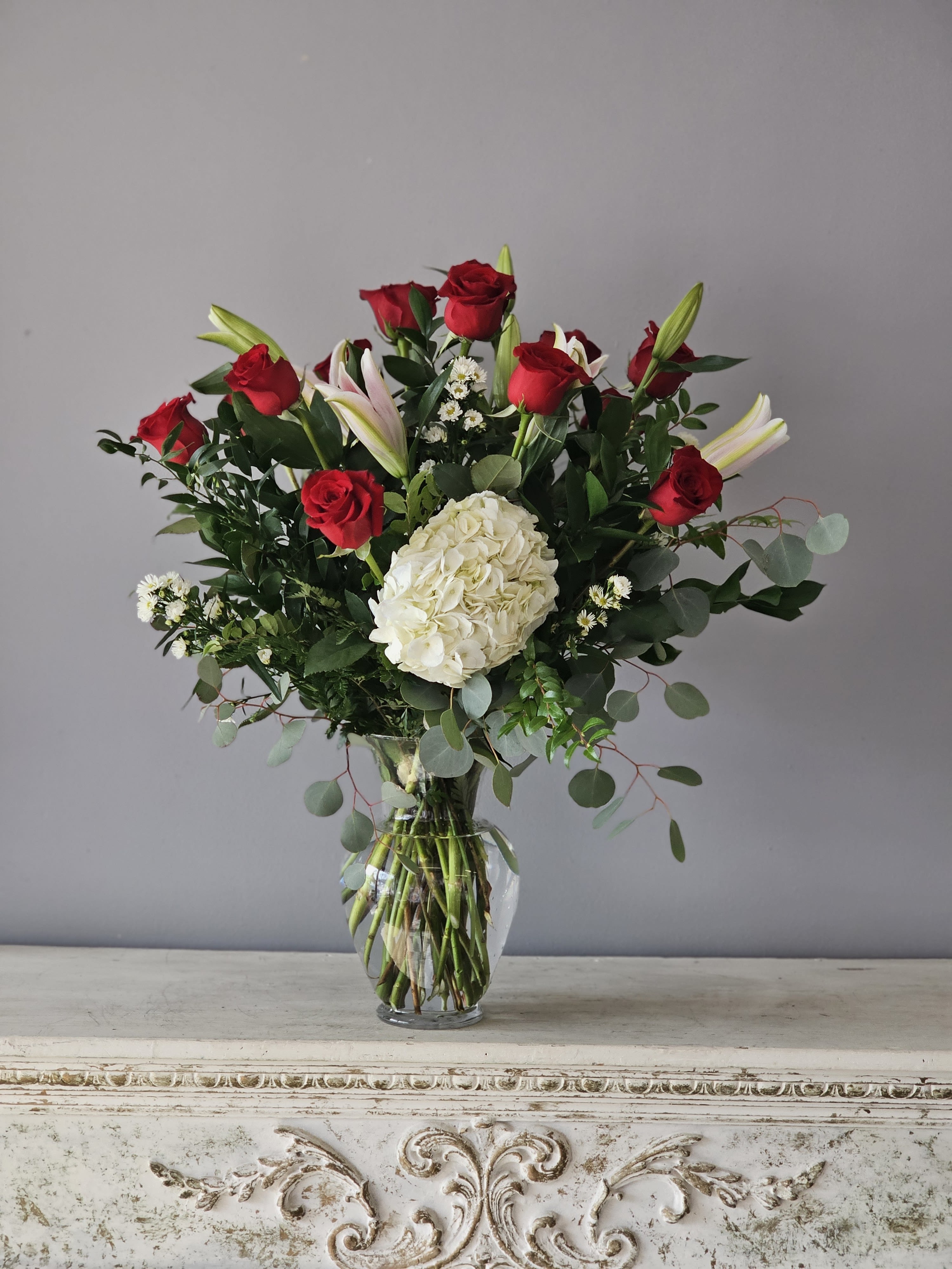 Roses ands Lilies - One dozen beautiful red roses arranged in a glass vase with lilies and hydrangea.