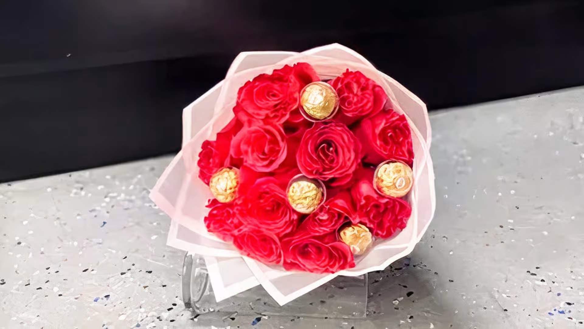 SMALL BOUQUET ROSITA - 12 HOT PINK ROSES  5 FERRO ROCHER  PINK PAPER ( THE DESIGN OF PAPER WILL VARY DEPENDING ON THE SUPPLY)