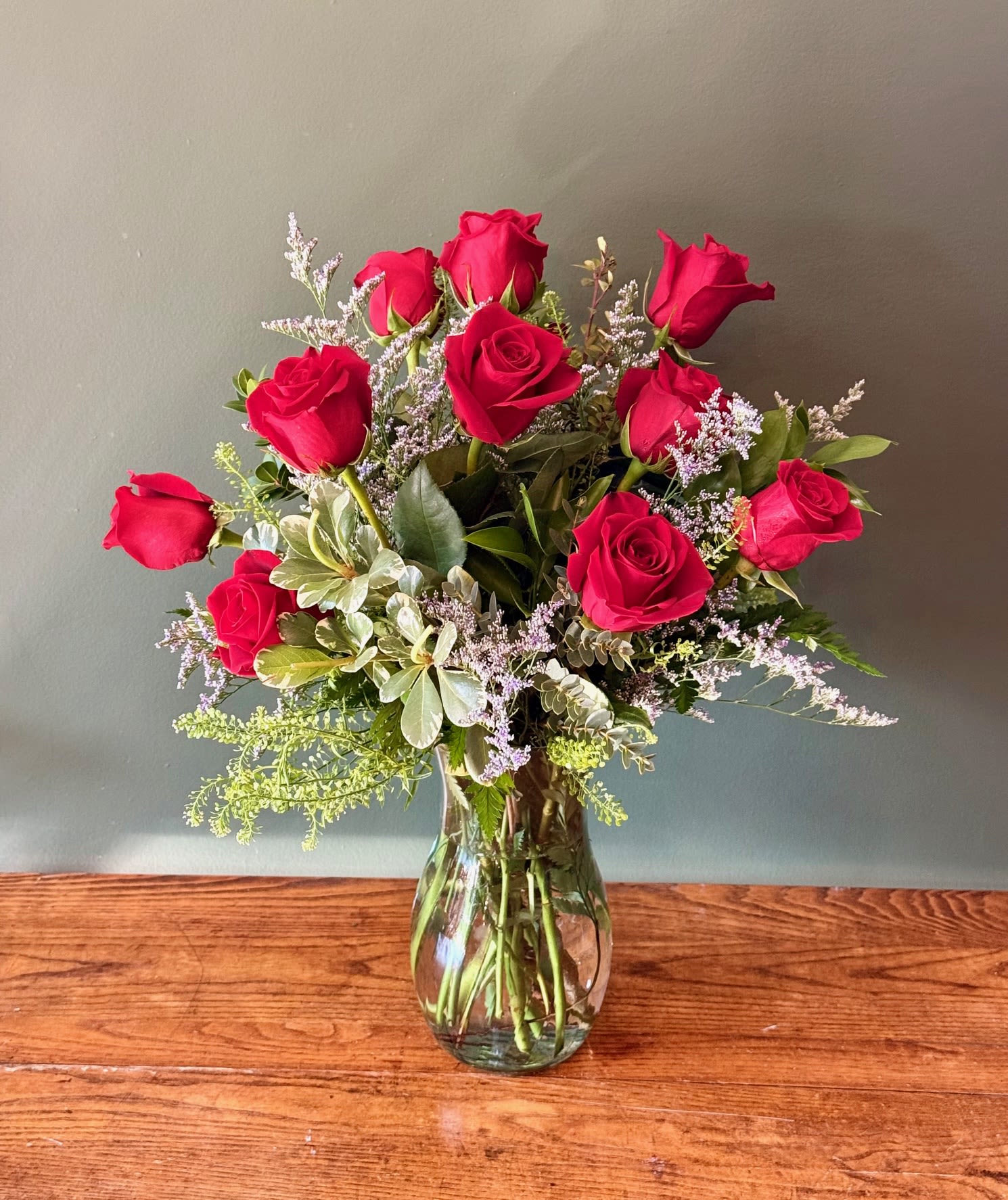 Dozen Red Roses - Timeless dozen red roses bouquet features 12 fresh, premium red roses, hand-arranged with lush greenery for an elegant presentation. a classic symbol of love and romance, it's perfect for Valentine's Day, anniversaries, birthdays, or just because. Featuring: - Ecuadorian Roses - Styled with premium seasonal foliage Presentation Options: Tall clear vase measuring approximately 9". Vase included in price. Every order includes: A custom message card - simply enter your message at checkout and we'll take care of the rest.   As a local florist in Charleston South Carolina, everything is made fresh by us here at our flower shop Downtown Charleston.