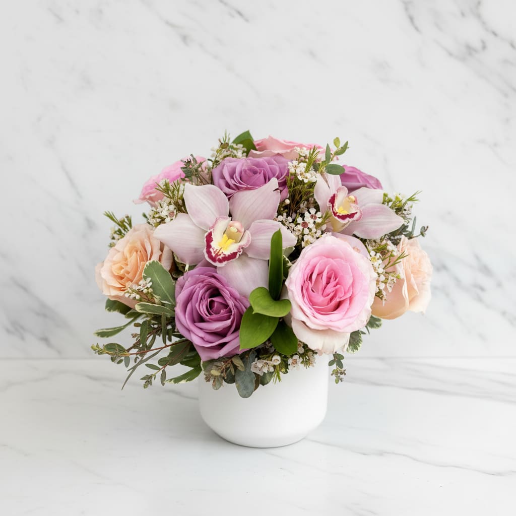 My Fair Lady - Understated elegance shines in this charming collection of 9 pastel roses, orchid blooms and seasonal foliage; designed to highlight the simple beauty that roses have to offer. Arranged in a keepsake ceramic pot. Cat and dog friendly flowers.