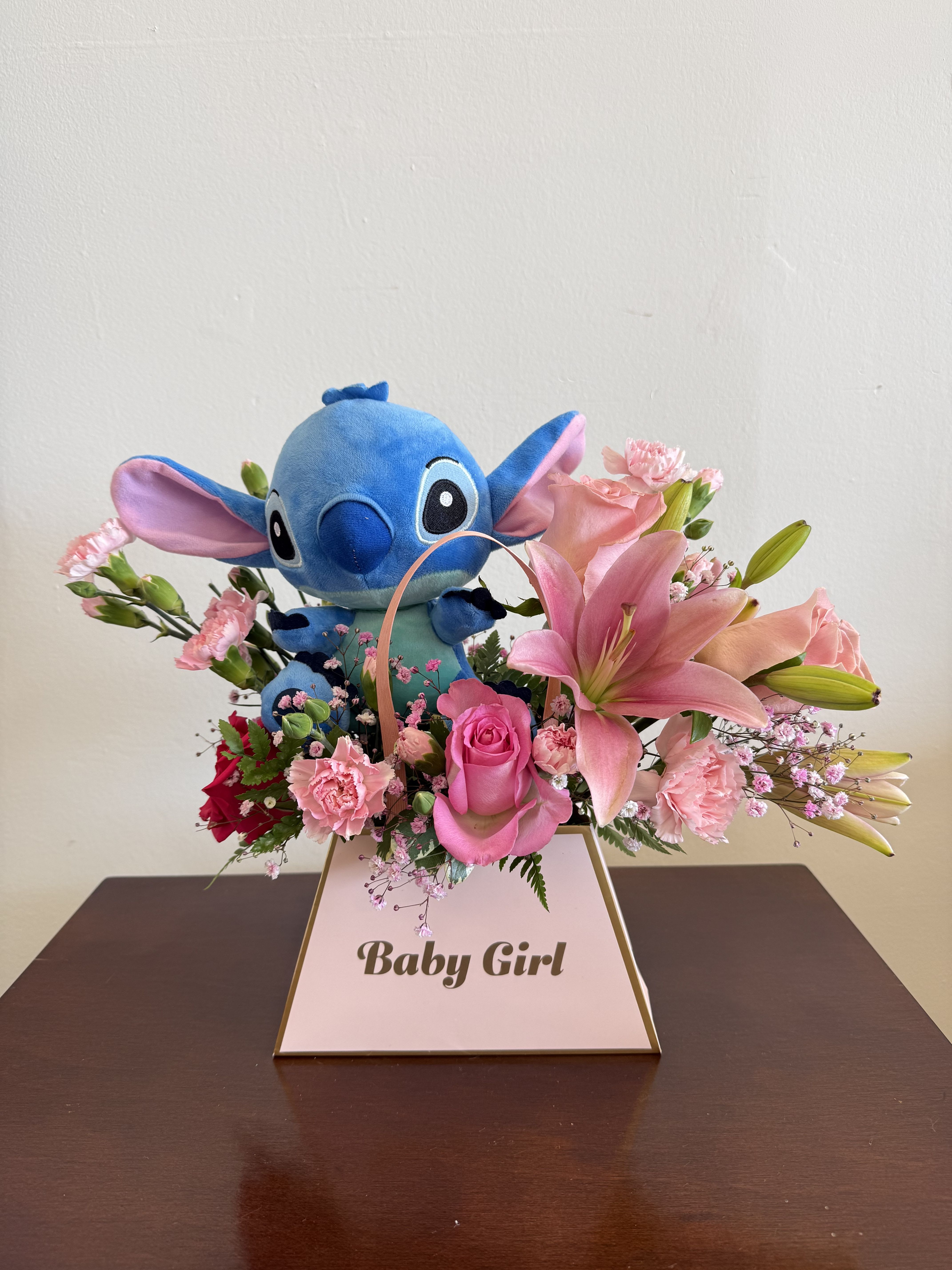 Pink lily and rose arrangement with blue plush toy in a Baby Girl box.