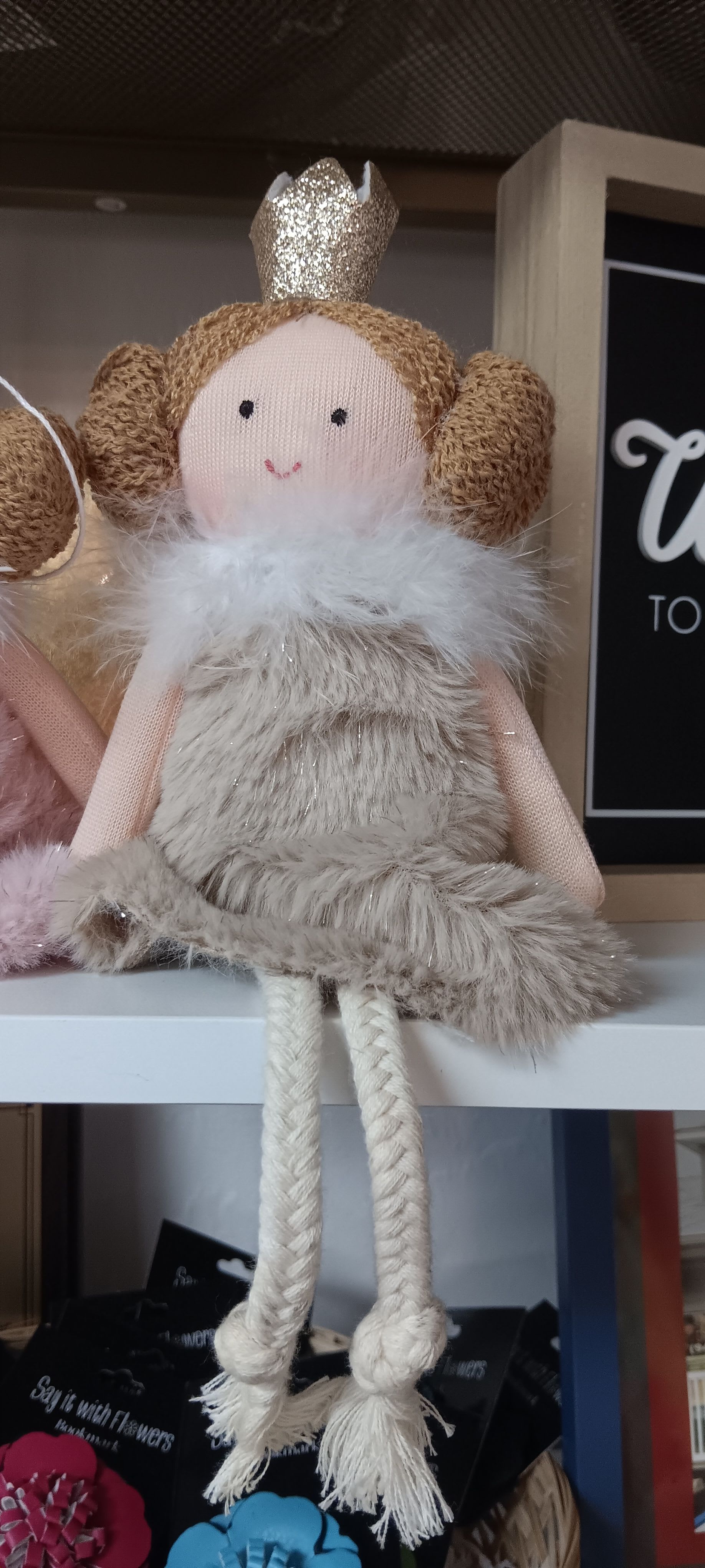 Plush princess doll with glitter crown, furry beige dress, and rope legs sitting on a shelf