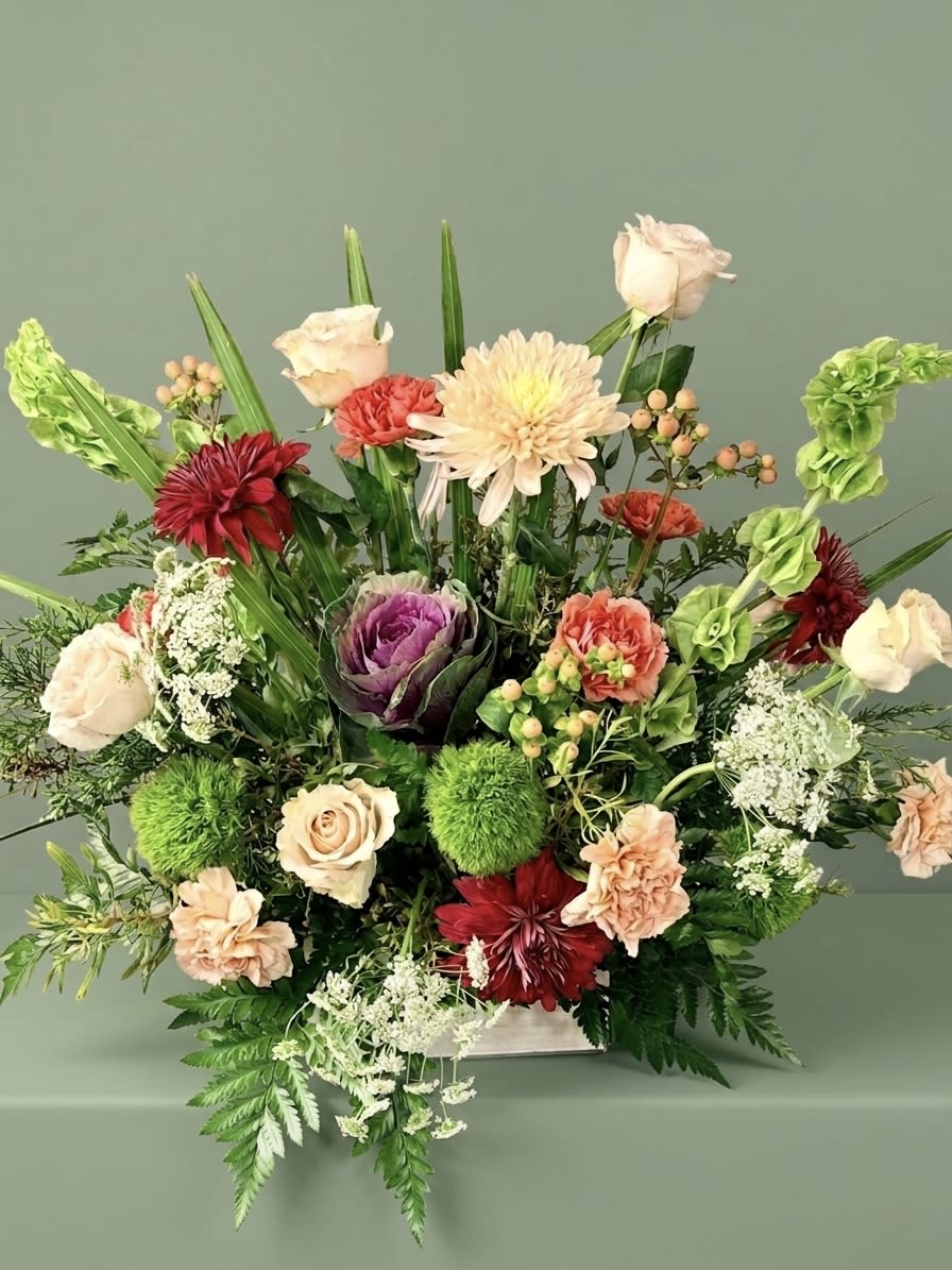 Veranda Signature Easter  - Our signature take on Easter. A wild, sophisticated blend of vintage roses, Ornamental Kale, Vintage carnations, Green Trick, Bells of Ireland, and Queen Anne’s Lace. The perfect centerpiece for a meaningful celebration.