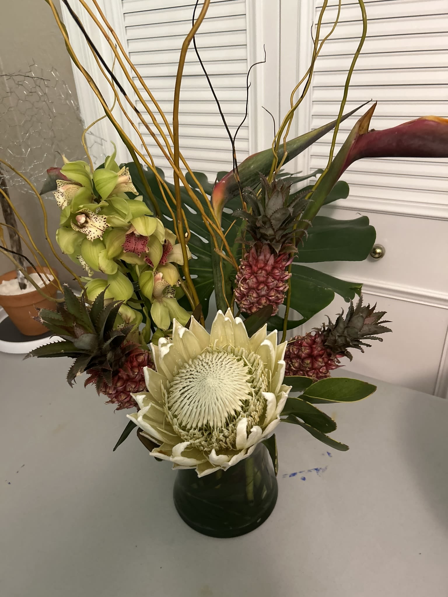 Tropical King Protea jewel - A king Protea commands this arrangement surrounded by orchids and various tropical elements.