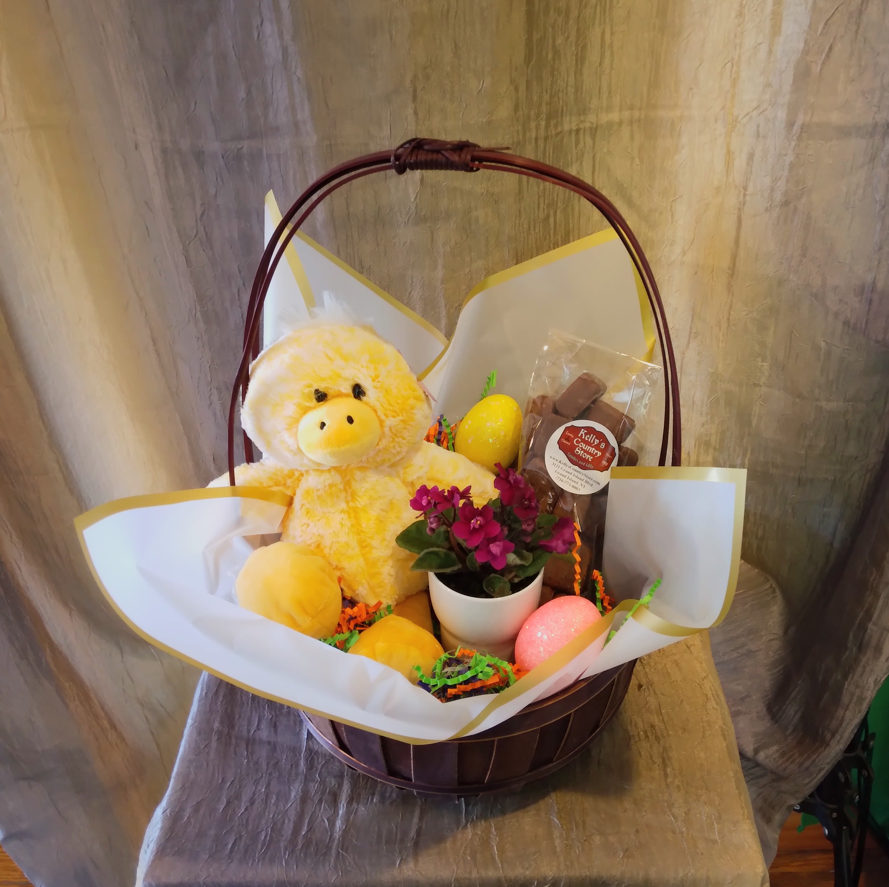 Easter Gift Bundle ~ Flower A Day - This darling little bundle contains (1) Duckie Plushie, (1) 1/2 lb. bag of Kelly's Country Store Chocolate Sponge Candy, (1) Mini African Violet Planter, and decorative Easter eggs. Final Product will be wrapped in Cellophane and decorated with a festive Easter bow. Send to your favorite chocolate or plant lover this Easter! 