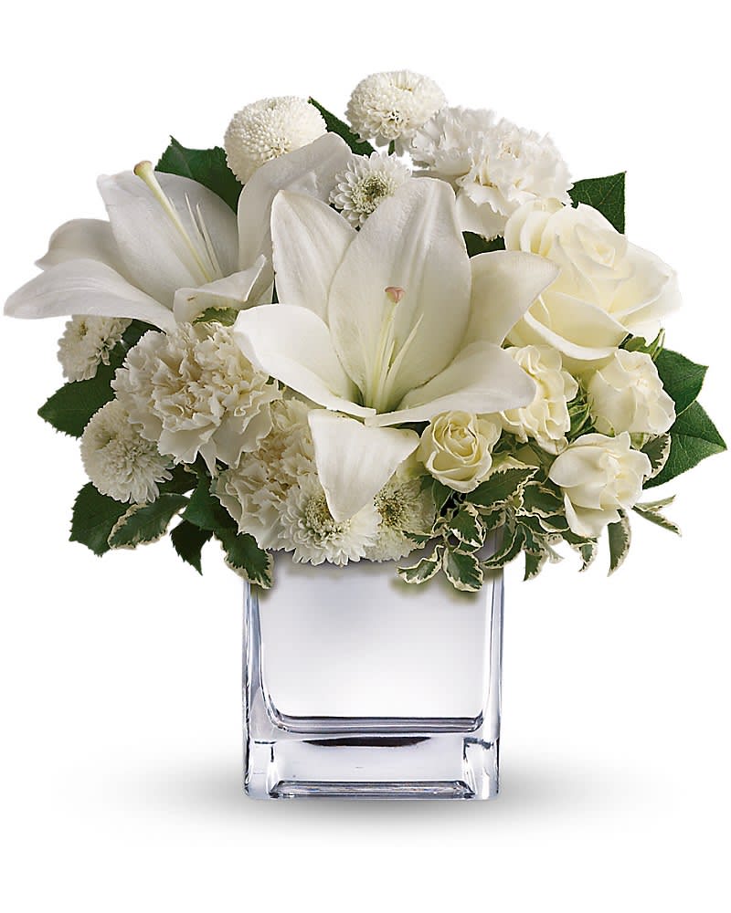 Peace &amp; Joy Bouquet - There's no business like snow business when it's expressed as dazzlingly as it is in this snowy white array of roses lilies and more in a chic mirrored silver cube. Think how thrilled they'll be when this stunning bouquet arrives at the door. The elegant holiday bouquet includes white roses white Asiatic lilies white carnations and white button spray chrysanthemums accented with assorted greenery.