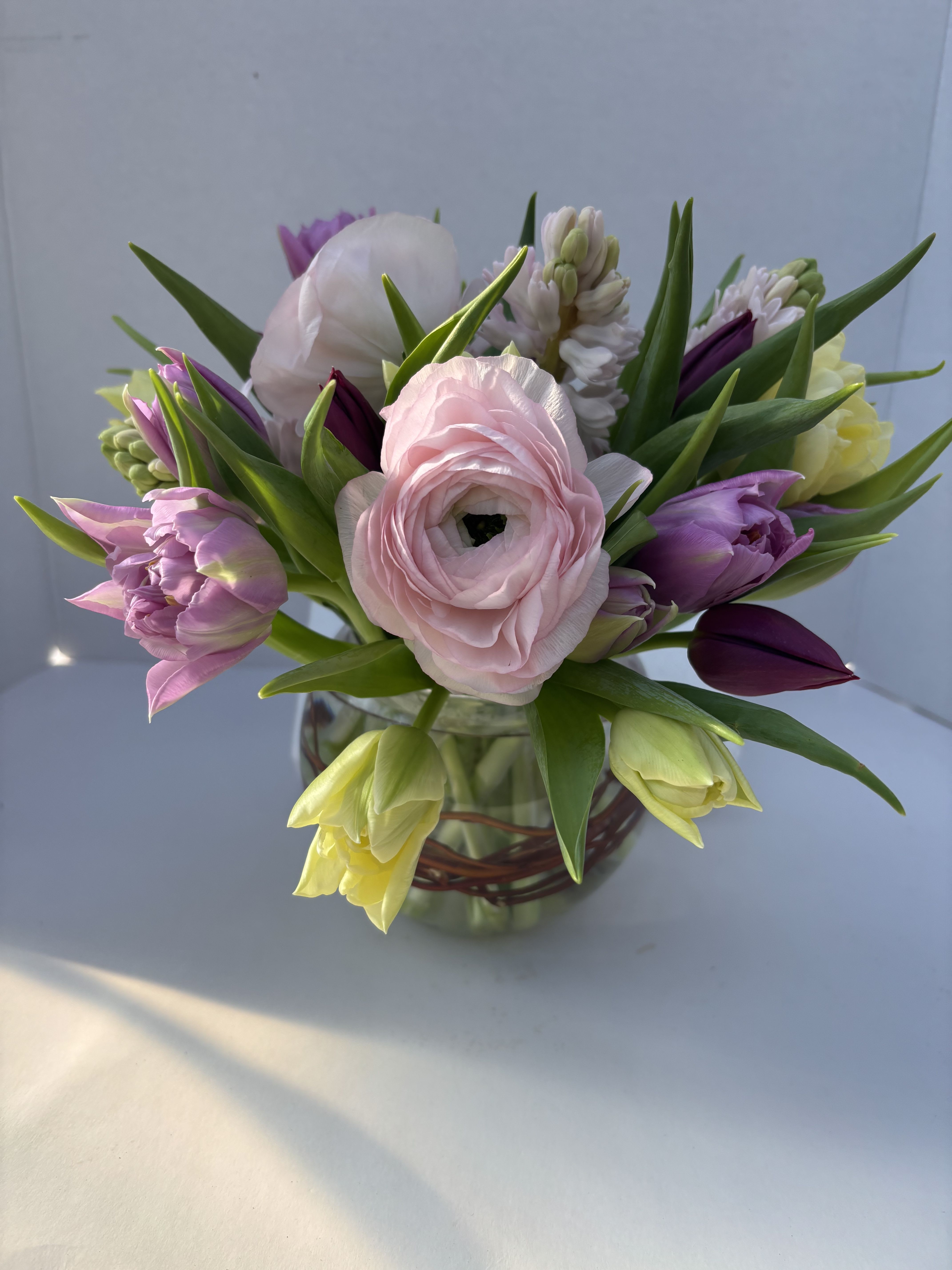 Spring Fling - A combination of pastel Spring flowers including ranunculas, tulips, and hyacinth  * colors of flowers will vary