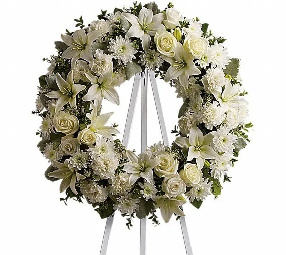 Serenity Wreath - A ring of fragrant bright white blossoms will create a serene display at any funeral or wake. This classic wreath is delivered on an easel and is a thoughtful expression of sympathy and admiration. A standing wreath created from fresh white flowers such as roses Asiatic lilies carnations and cushion spray chrysanthemums - accented with greenery - is delivered on an easel.