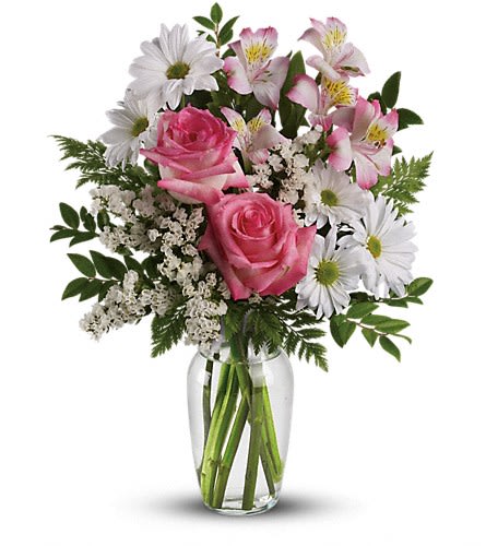 Vase arrangement of pink roses, white daisies, and pink alstroemeria in a clear glass vase