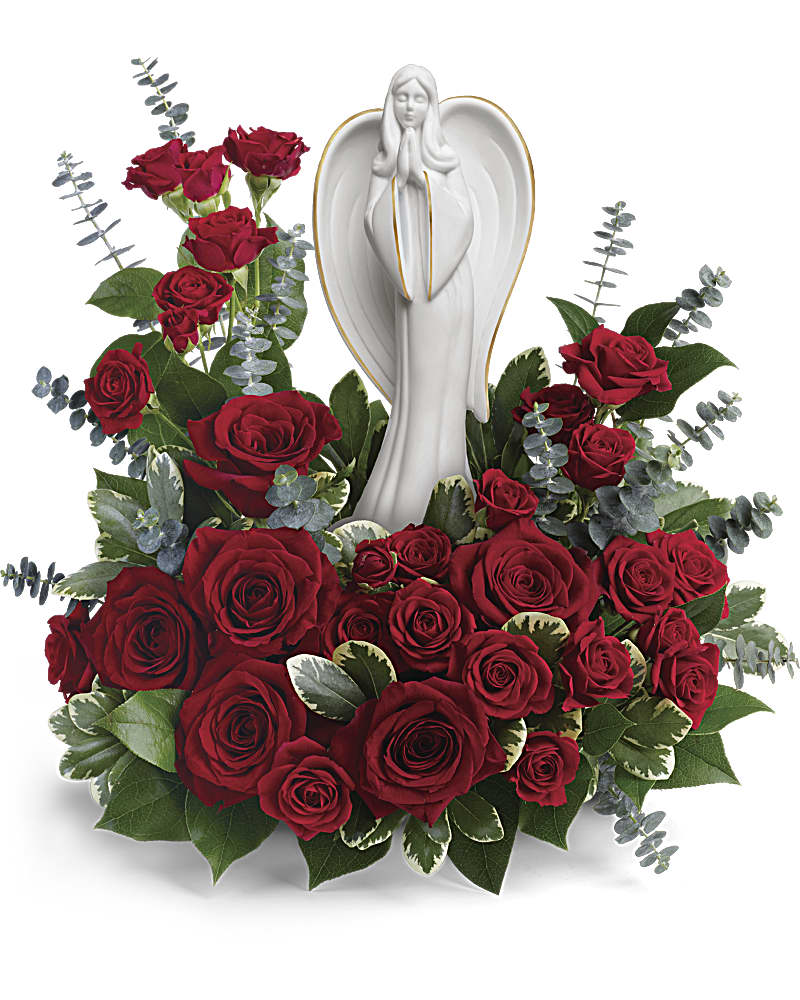 Red rose sympathy arrangement surrounding a white ceramic praying angel figurine
