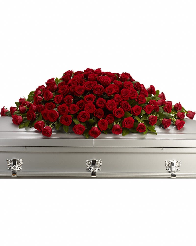 Large blanket of red roses arranged as a casket spray on a closed silver casket