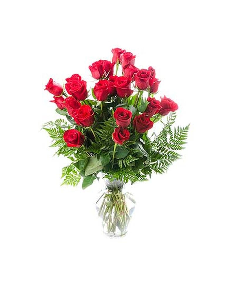 Tall arrangement of long-stemmed red roses in a clear glass vase