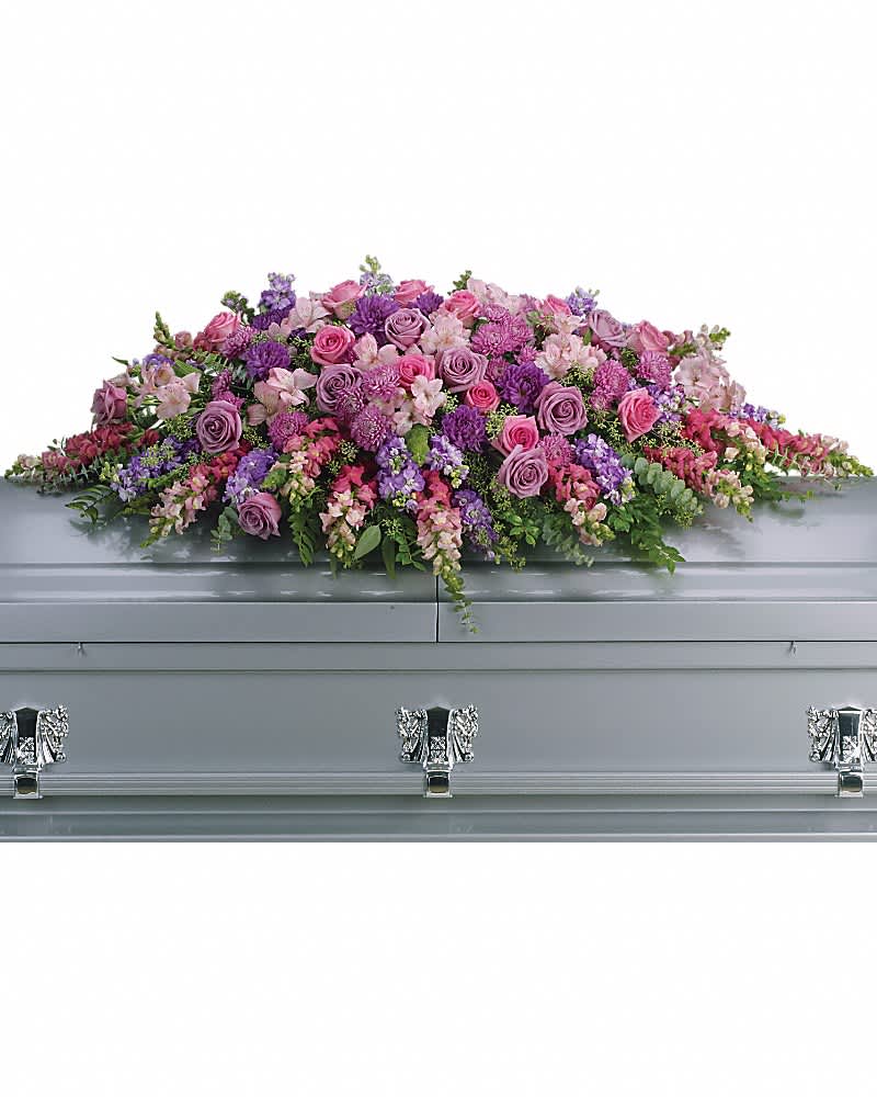 Long spray of pink and purple flowers arranged on top of a silver casket