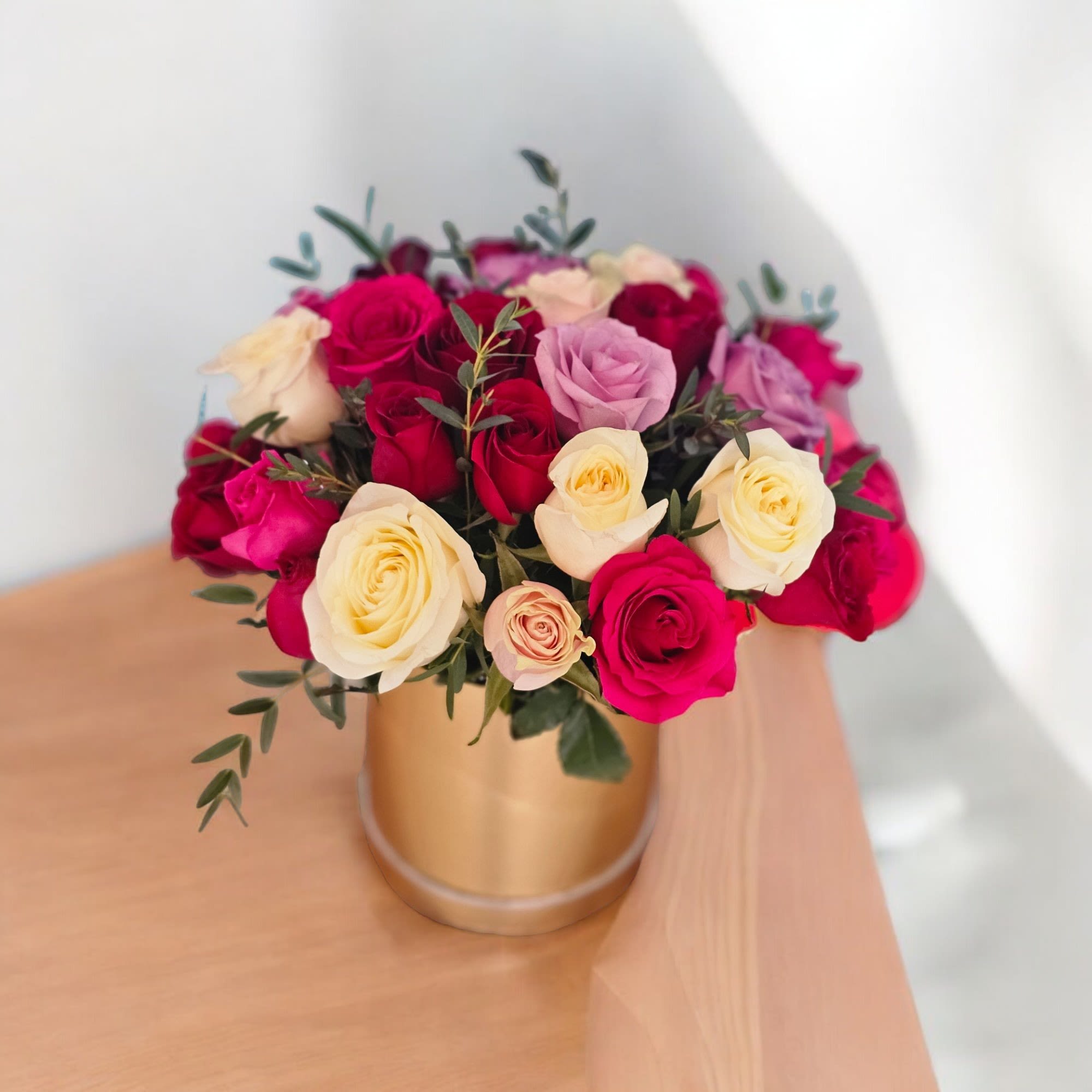 Golden Rose Bouquet - This arrangement is luxurious assortment of eighteen roses in various colors, complemented by lush greenery and delicate filler.